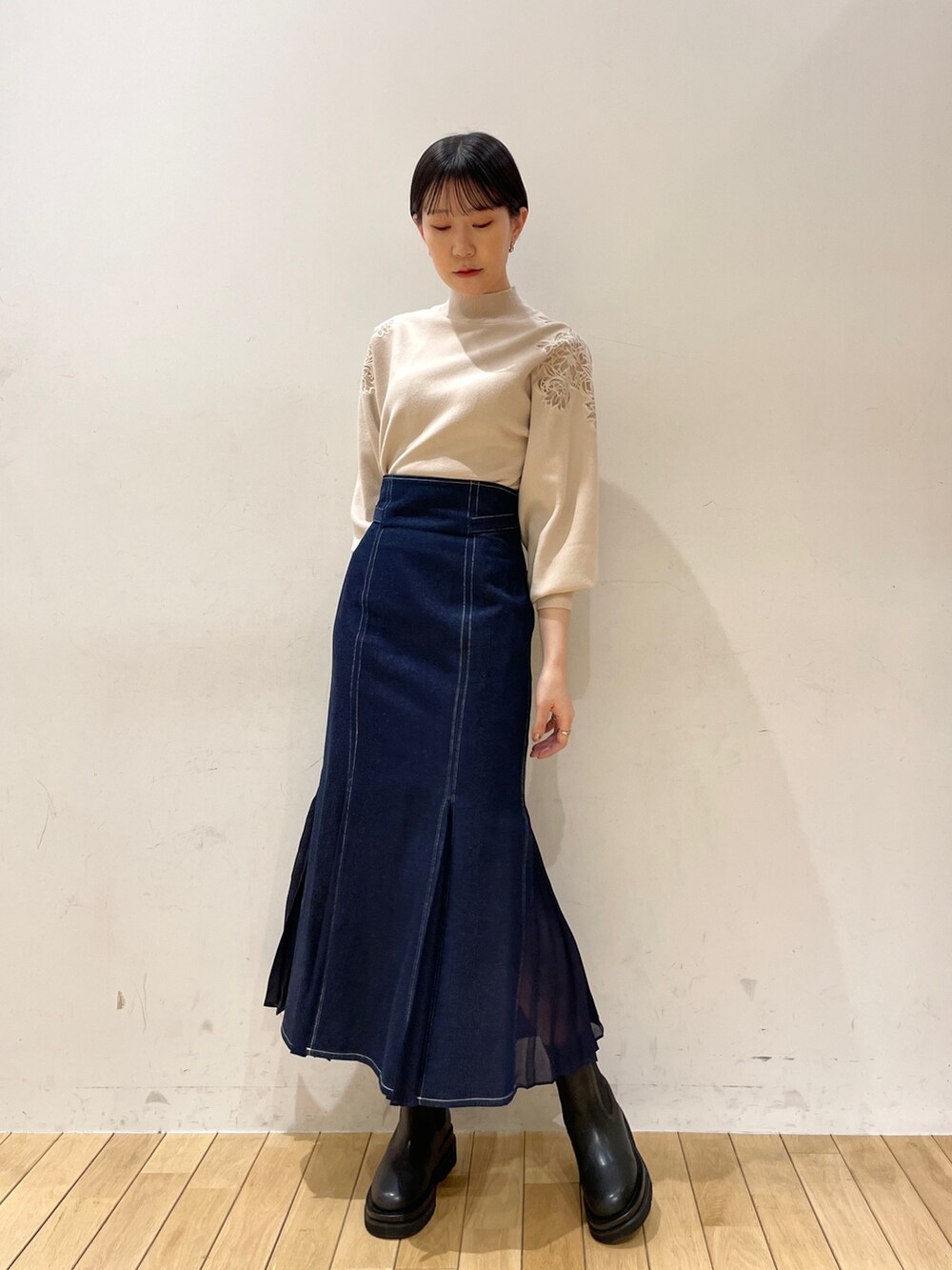 ブラック系のその他アウター、ホワイト系のニット/セーター、ブルー系のスカートを着用したレディースの冬コーディネートの9枚目の写真