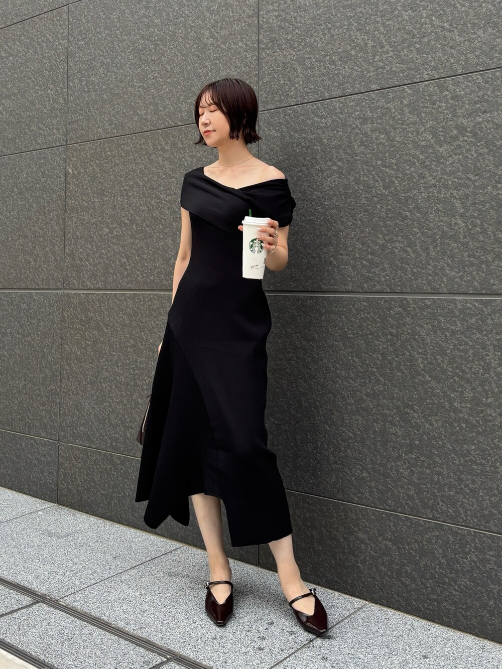 ブラウン系のパンプス、ブラウン系のボストンバッグ、ブラック系のワンピースを着用したレディースの夏コーディネートの2枚目の写真