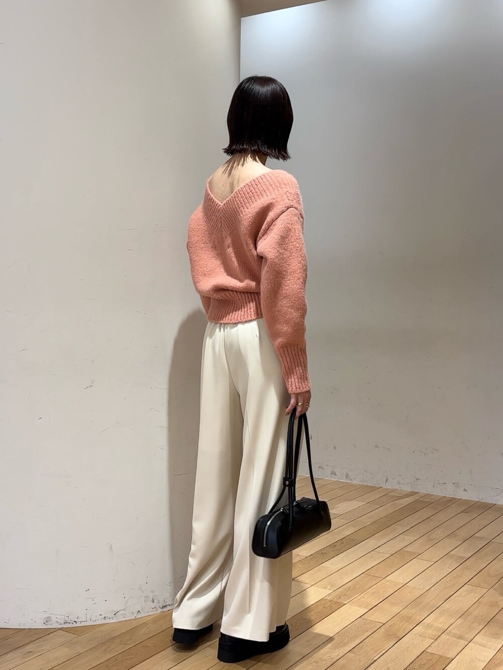 ピンク系のニット/セーター、ブラック系のショルダーバッグ、ホワイト系のその他パンツを着用したレディースの冬コーディネートの4枚目の写真