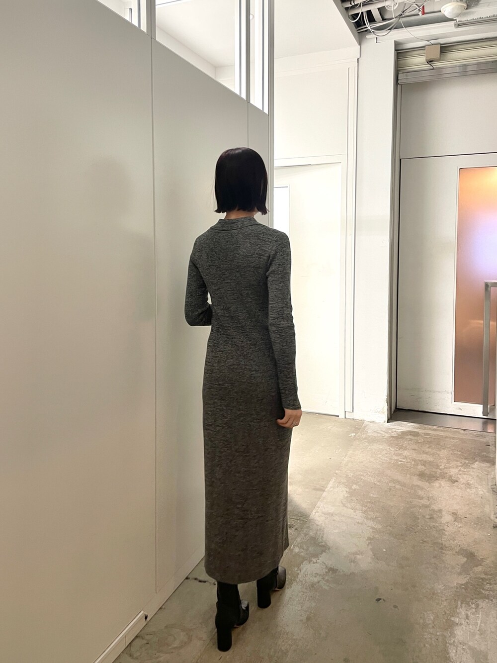 ブラック系のブーツ、グレー系のワンピースを着用したレディースの春コーディネートの5枚目の写真