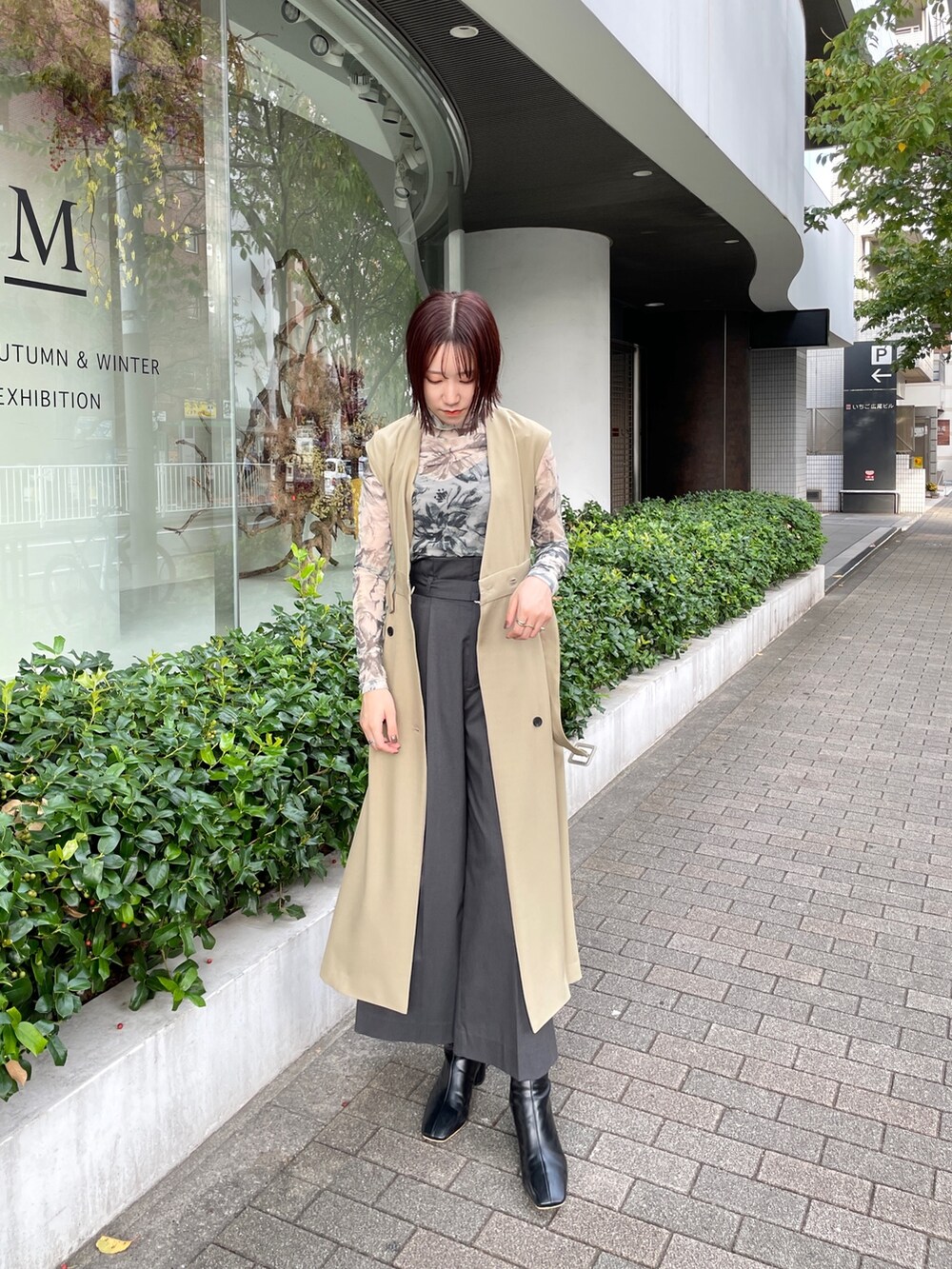 ブラック系のブーツ、グレー系のその他パンツ、グリーン系のトレンチコートを着用したレディースの冬コーディネートの2枚目の写真