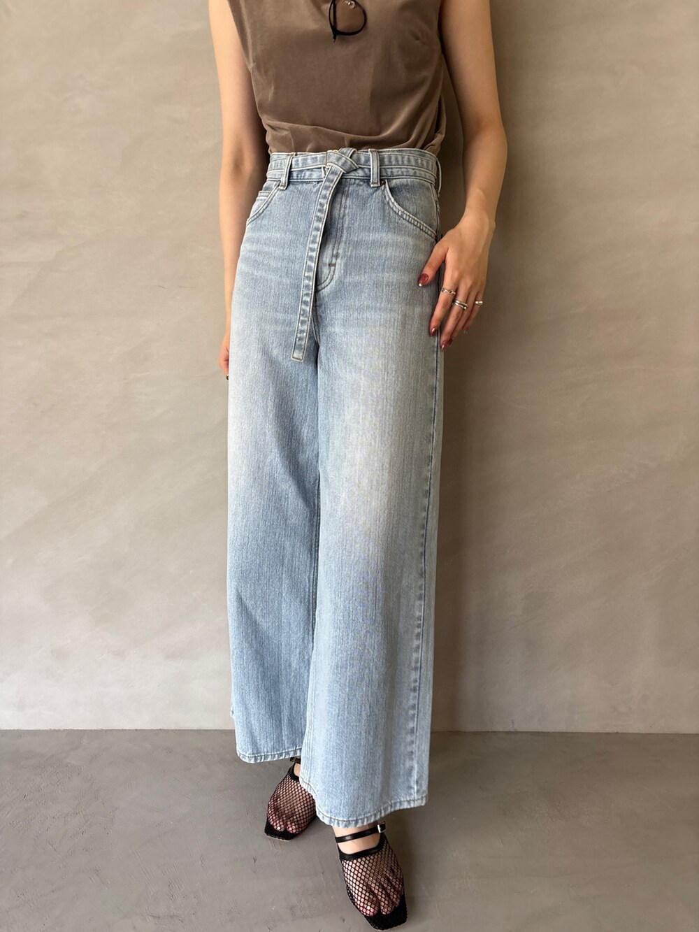 ブルー系のデニムパンツ、ブラック系のサンダル、ブラウン系のTシャツ/カットソーを着用したレディースの夏コーディネートの6枚目の写真