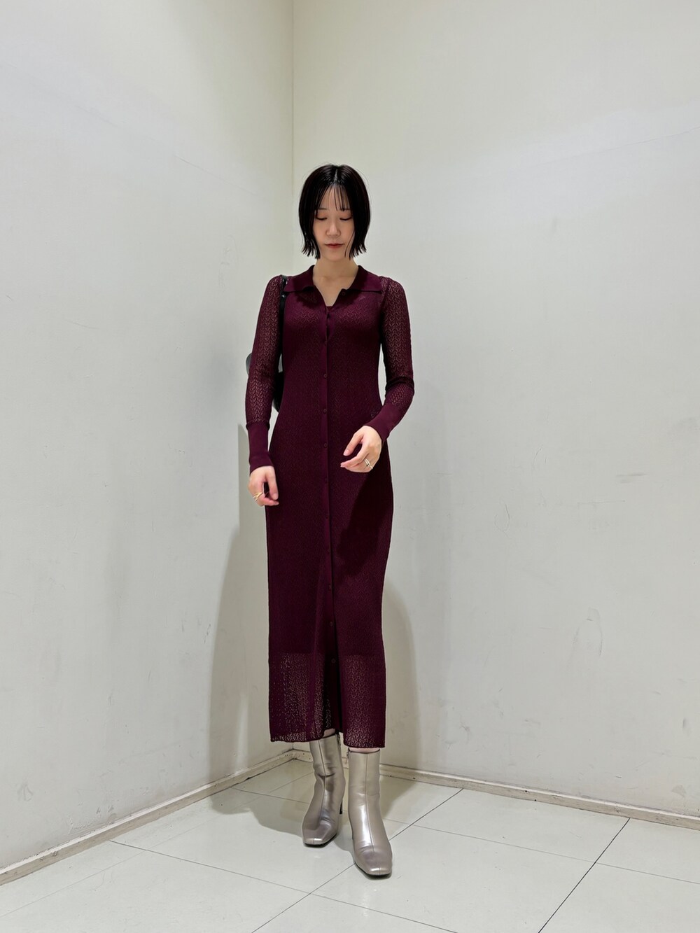 パープル系のワンピース、ブラック系のショルダーバッグ、シルバー系のブーツを着用したレディースの秋コーディネートの2枚目の写真