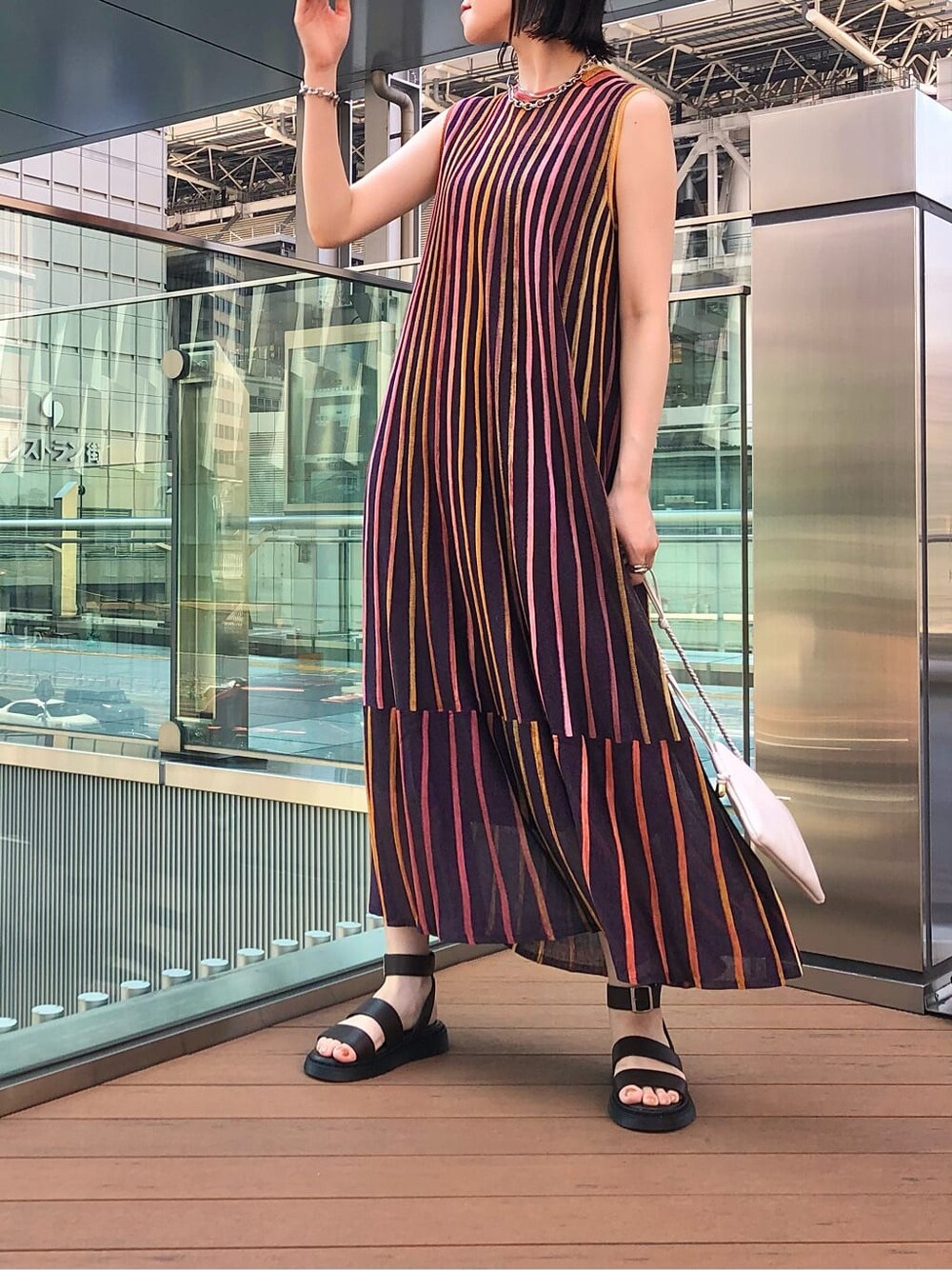 ホワイト系のショルダーバッグ、パープル系のワンピース、ブラウン系のサンダルを着用したレディースの夏コーディネートの2枚目の写真