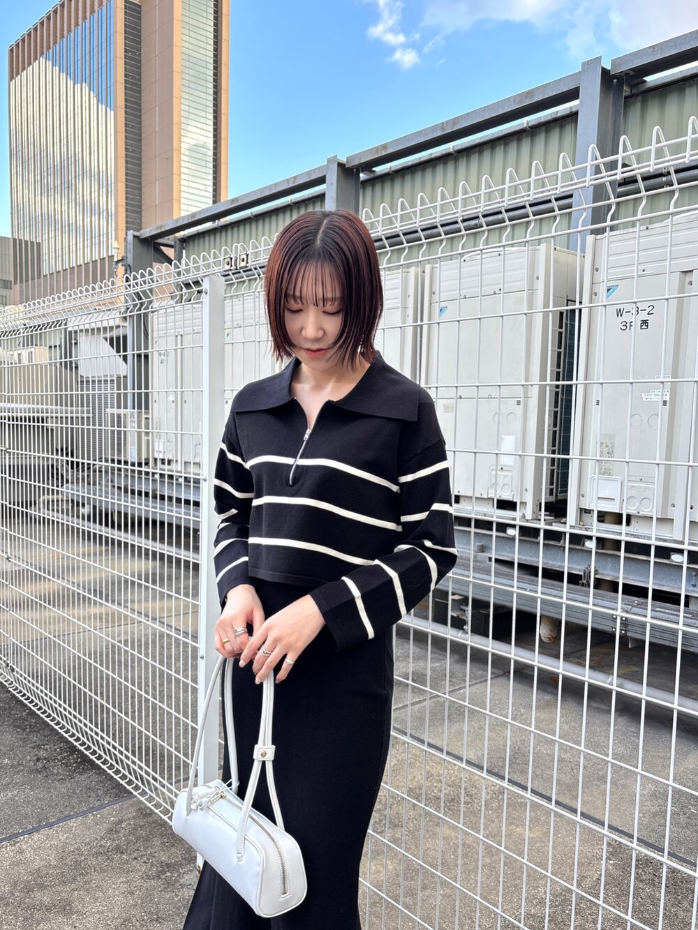 ブラック系のニット/セーター、ブラック系のスカート、グレー系のムートンコートを着用したレディースの冬コーディネートの4枚目の写真