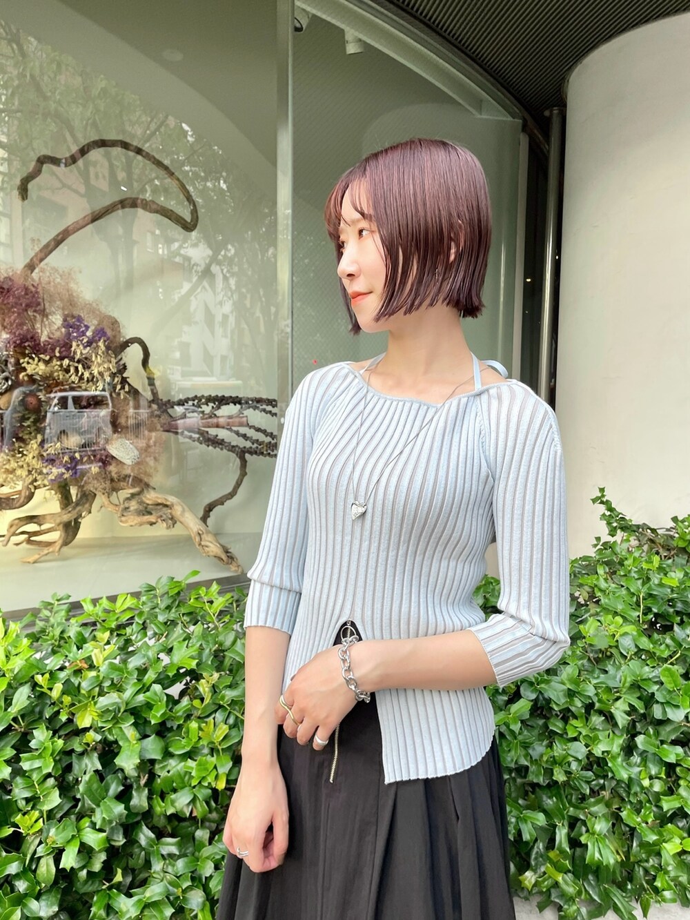 ブラック系のスカート、ブルー系のニット/セーター、ホワイト系のパンプスを着用したレディースの春コーディネートの7枚目の写真