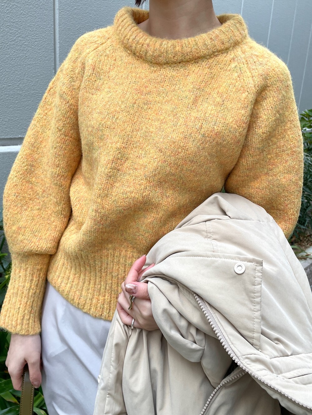 ベージュ系のダウンジャケット/コート、ホワイト系のスカート、ブラウン系のショルダーバッグを着用したレディースの冬コーディネートの9枚目の写真