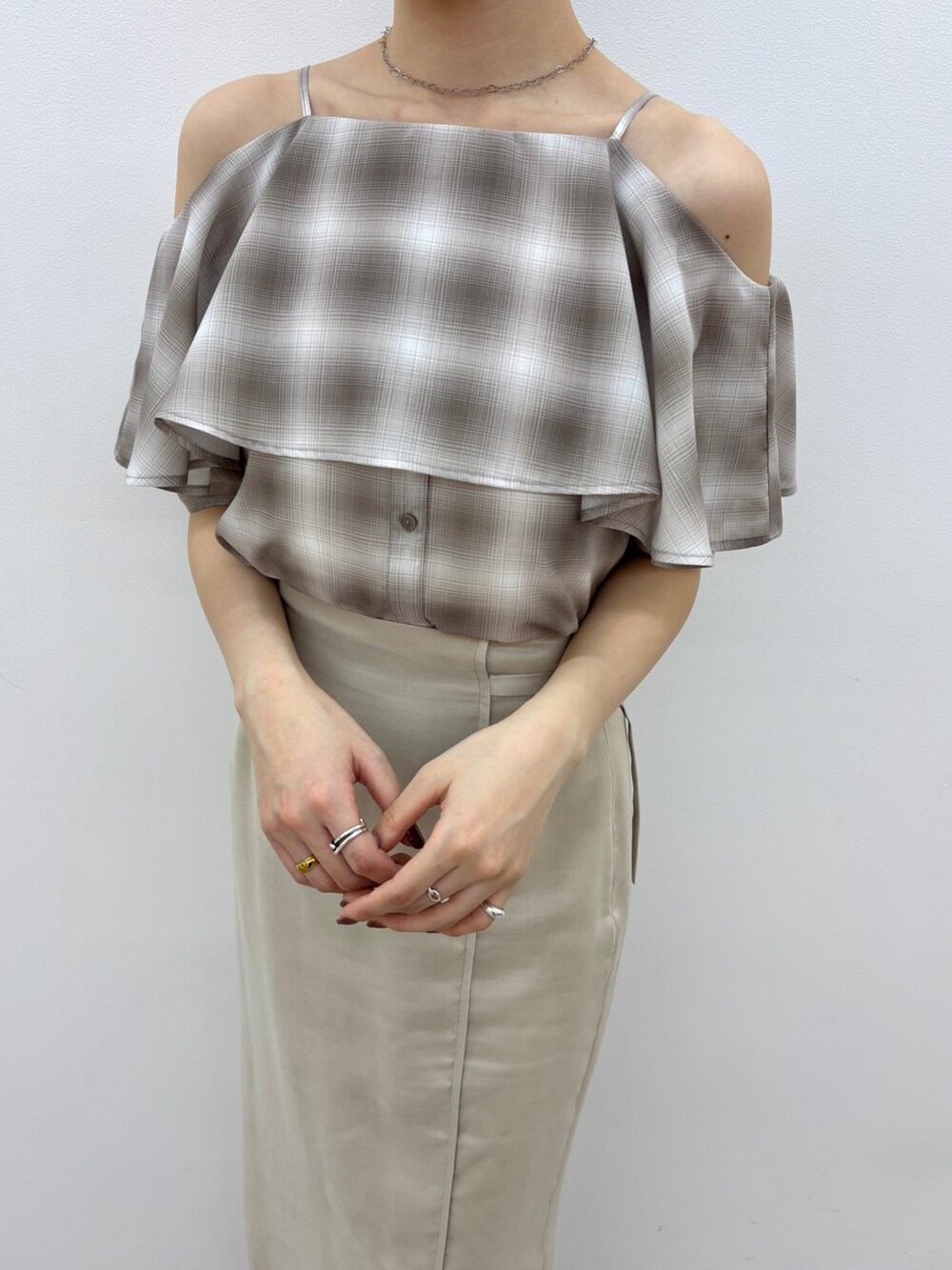 ベージュ系のシャツ/ブラウス、ホワイト系のスカート、ホワイト系のサンダルを着用したレディースの春コーディネートの6枚目の写真