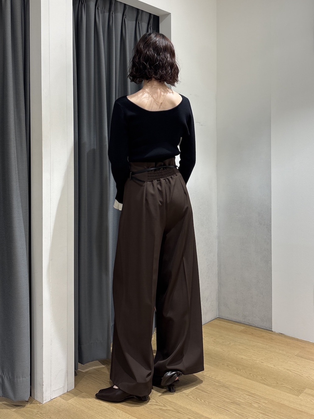 ブラック系のニット/セーター、ブラウン系のその他パンツ、レッド系のハンドバッグを着用したレディースの秋コーディネートの3枚目の写真