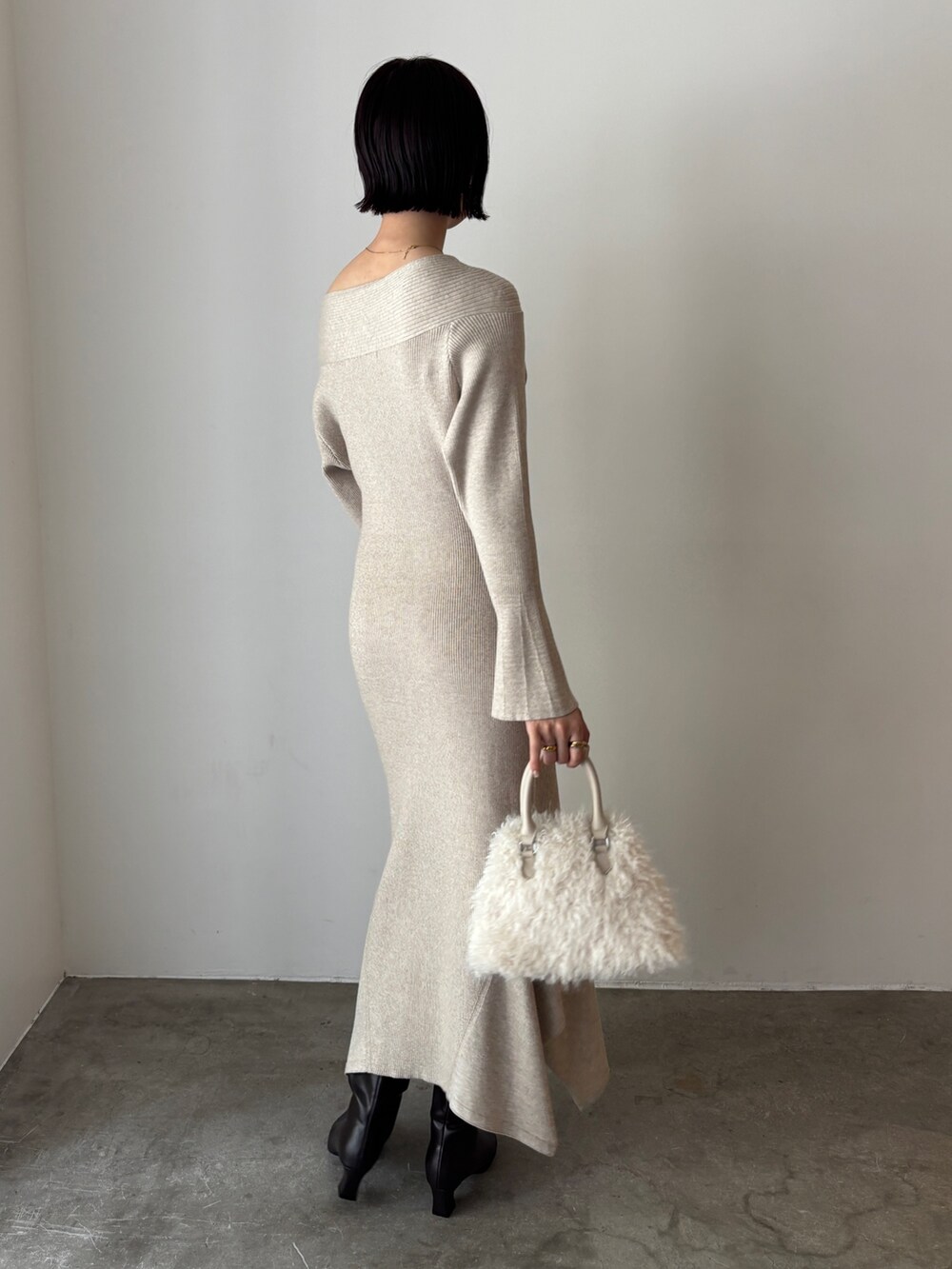 ベージュ系のワンピース、ホワイト系のボストンバッグ、ブラウン系のブーツを着用したレディースの秋コーディネートの3枚目の写真