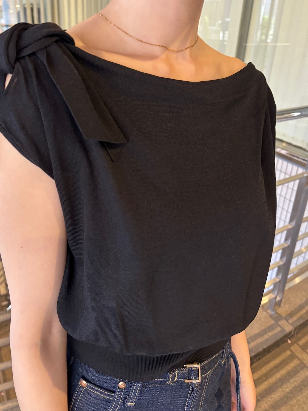 ブルー系のデニムパンツ、ブラック系のパンプス、ブラック系のニット/セーターを着用したレディースの春コーディネートの5枚目の写真