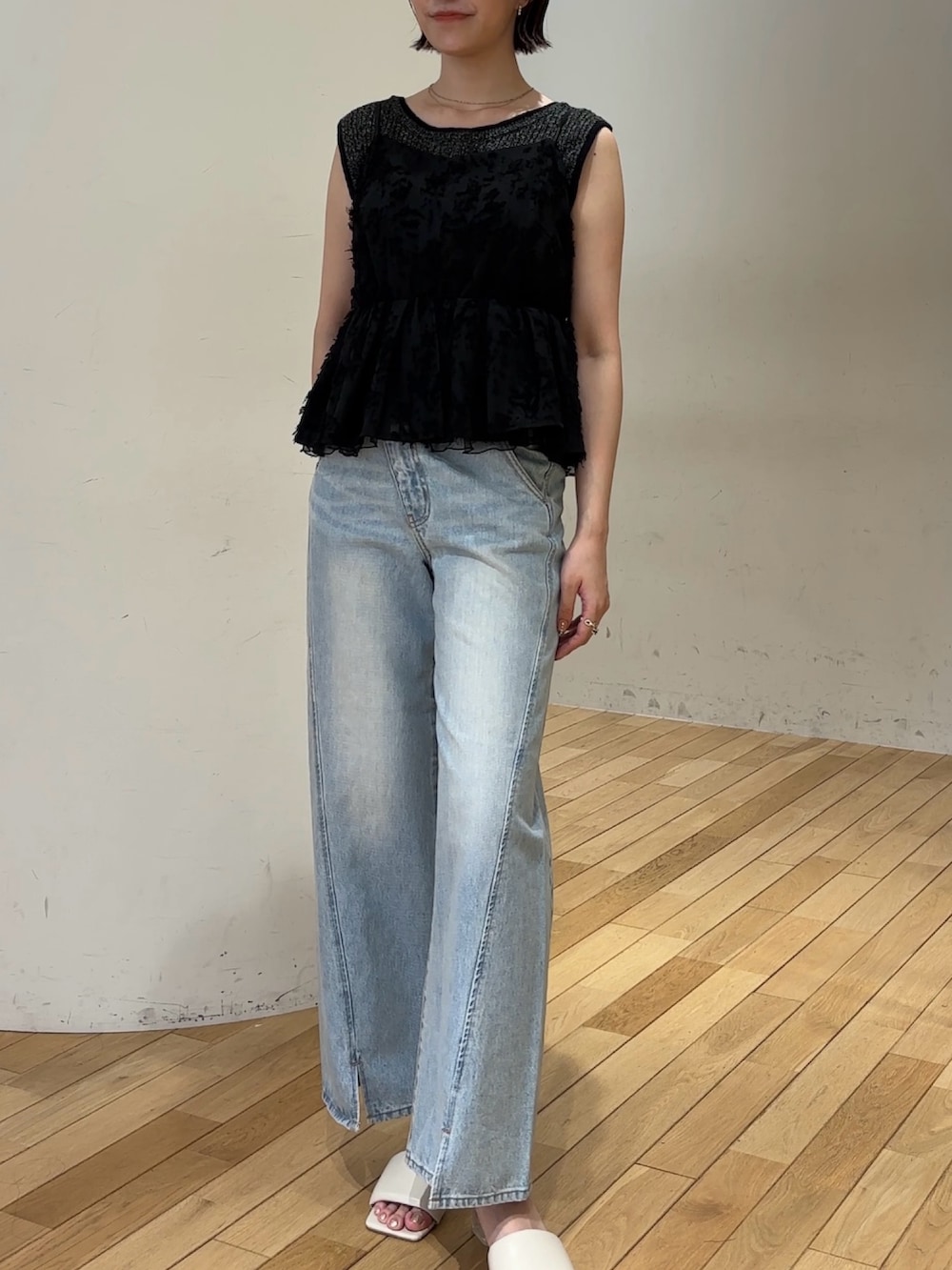 ブルー系のデニムパンツ、ブラック系のキャミソール、ブラック系のハンドバッグを着用したレディースの夏コーディネートの4枚目の写真