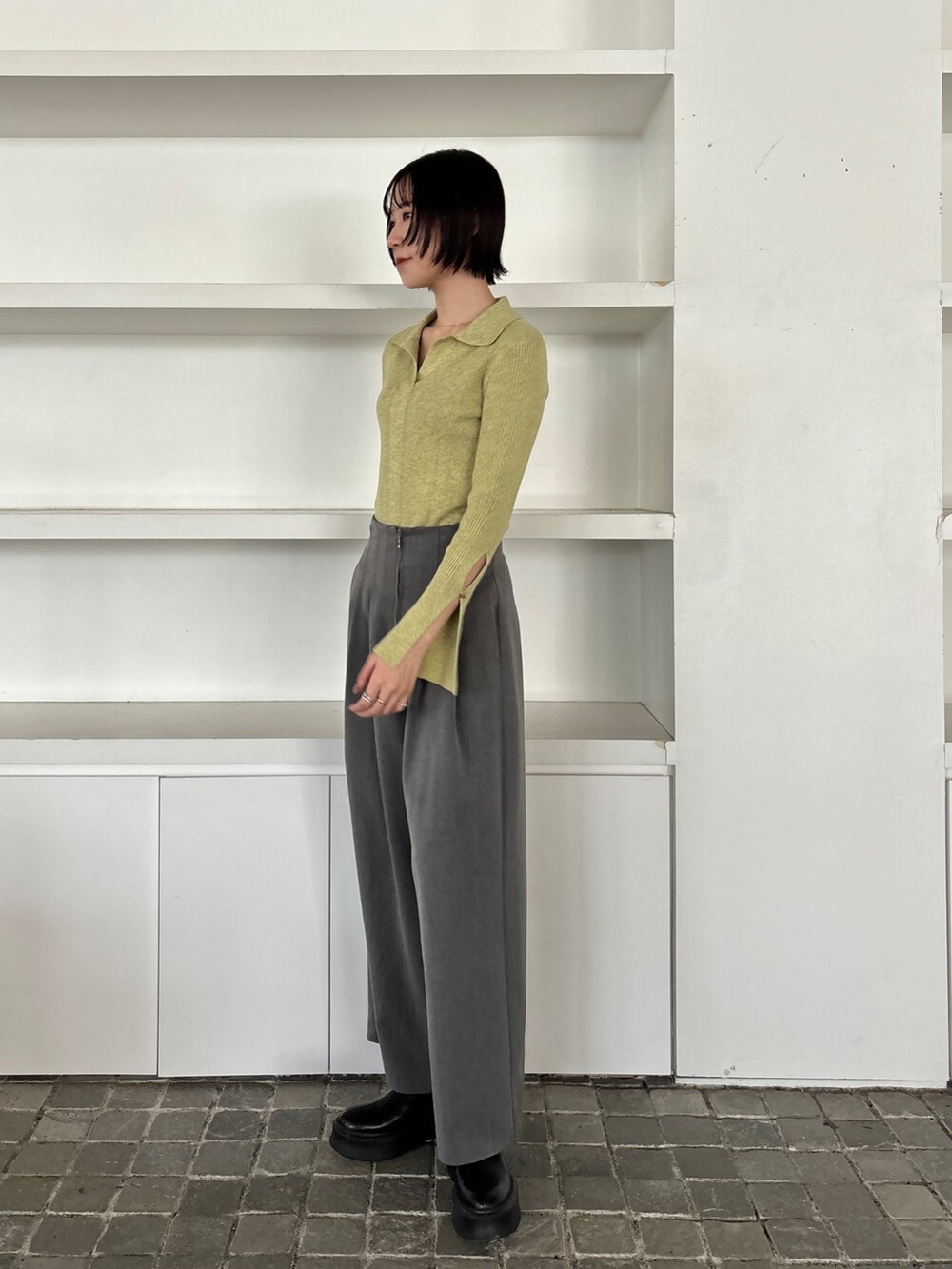 ブラック系のブーツ、グレー系のその他パンツ、グリーン系のニット/セーターを着用したレディースの冬コーディネートの3枚目の写真