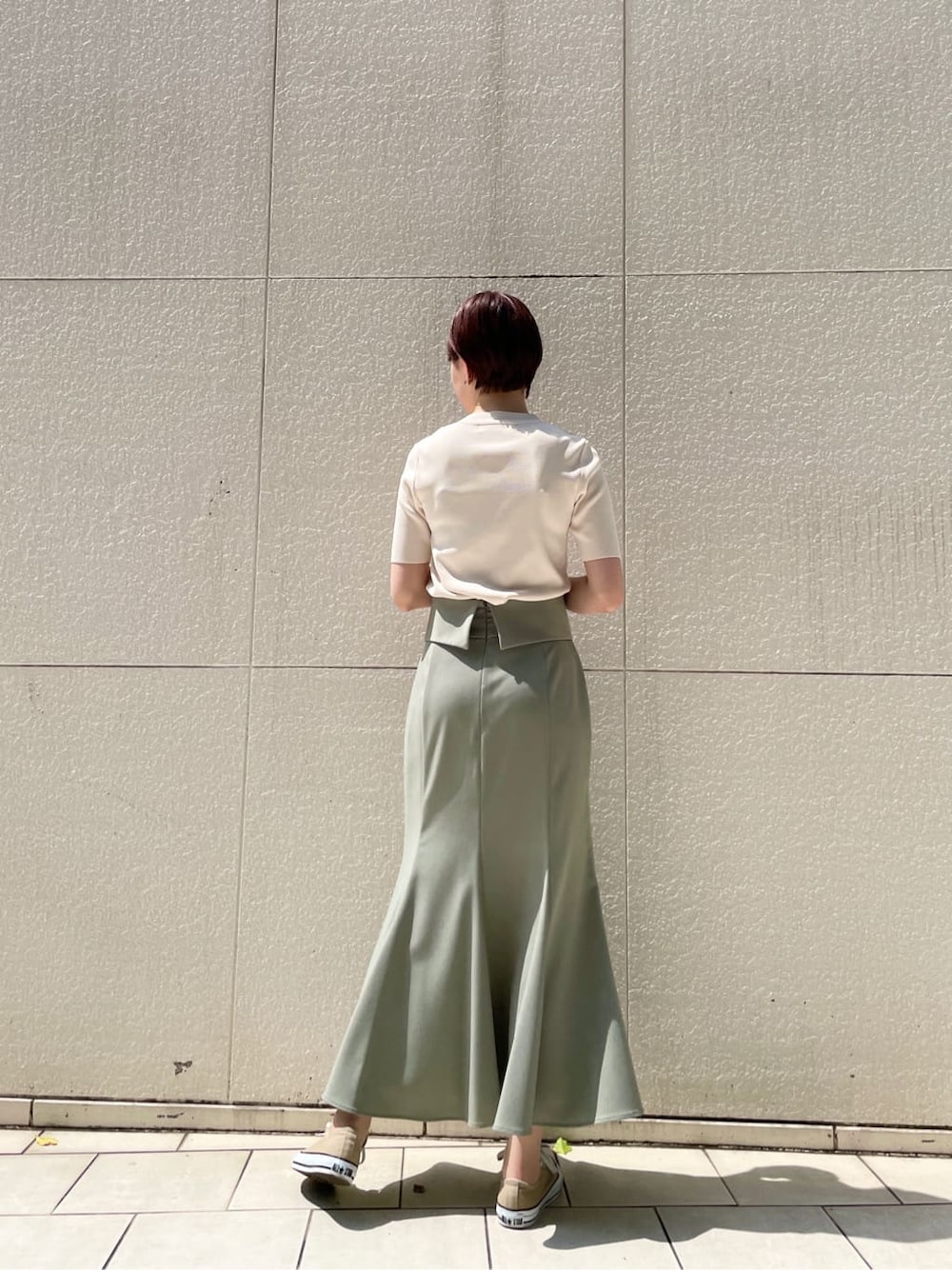 グリーン系のスカート、ホワイト系のニット/セーターを着用したレディースの春コーディネートの4枚目の写真