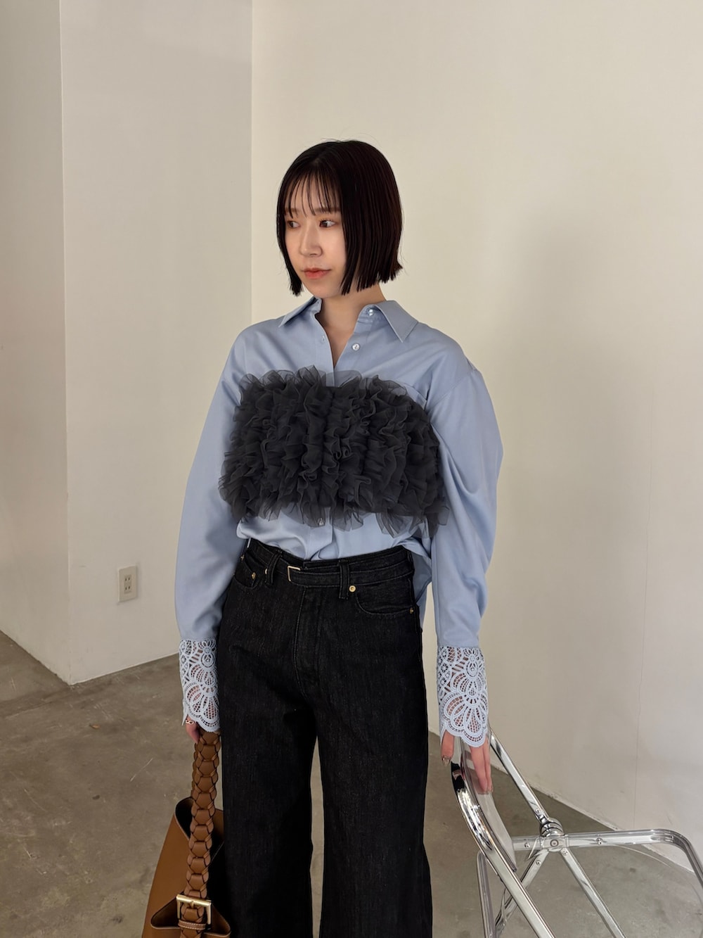 ブラック系のデニムパンツ、ブラウン系のサンダル、ブルー系のシャツ/ブラウスを着用したレディースの春コーディネートの2枚目の写真