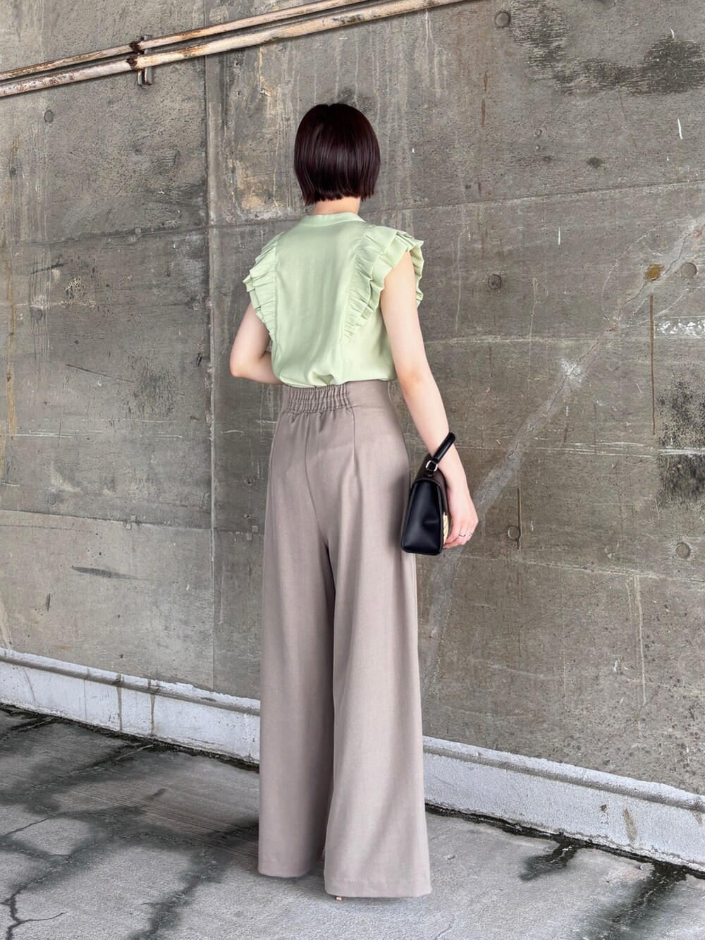 ブラウン系のその他パンツ、グリーン系のシャツ/ブラウス、ブラック系のハンドバッグを着用したレディースの夏コーディネートの4枚目の写真