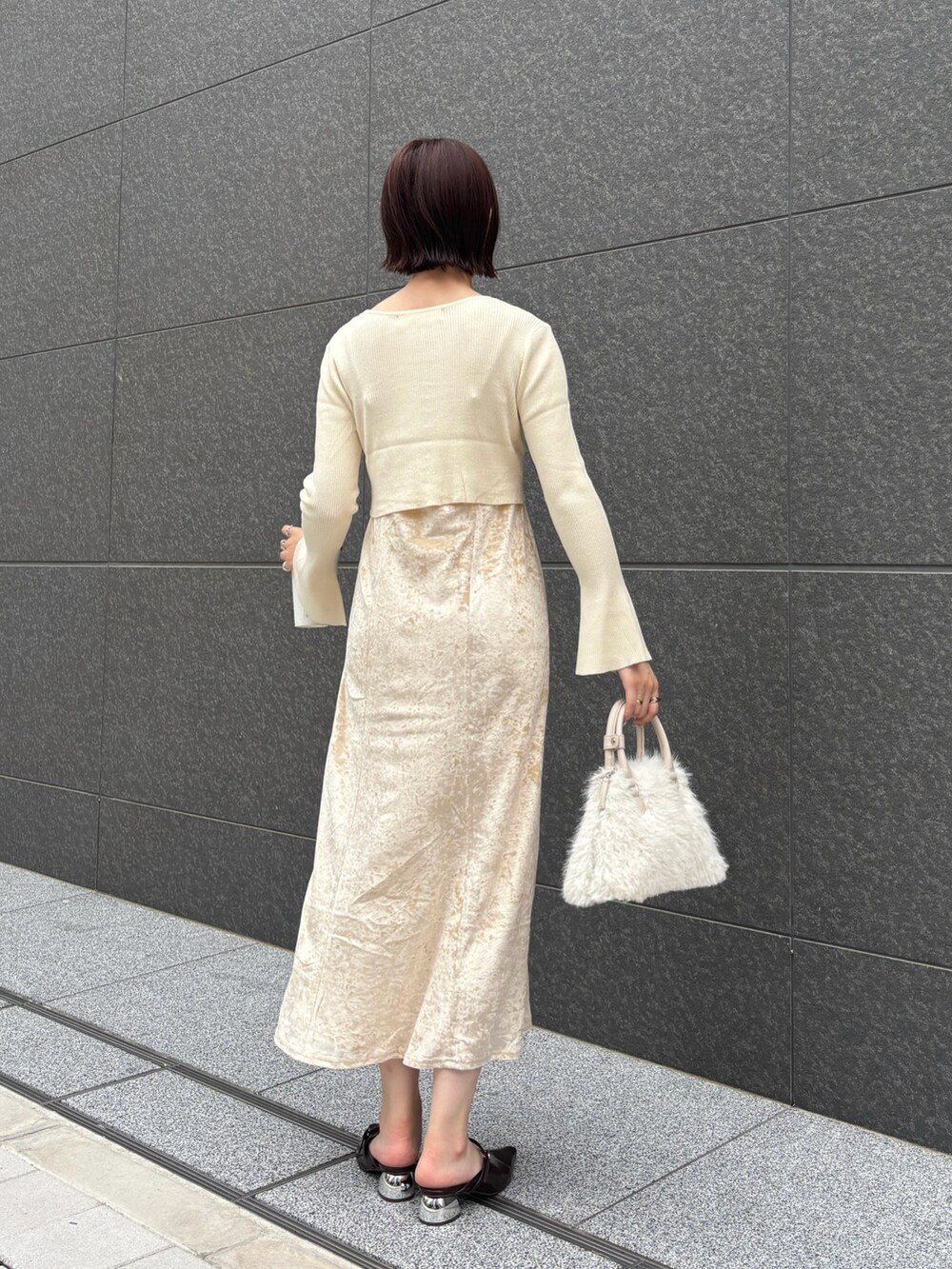 ベージュ系のワンピース、ホワイト系のボストンバッグ、ブラウン系のパンプスを着用したレディースの秋コーディネートの4枚目の写真