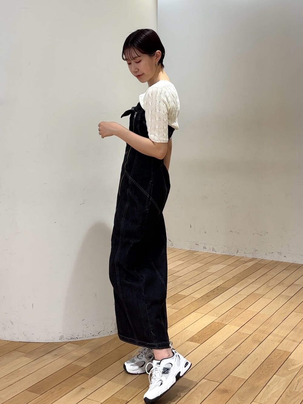 ブラック系のワンピース、ホワイト系のニット/セーターを着用したレディースの春コーディネートの2枚目の写真