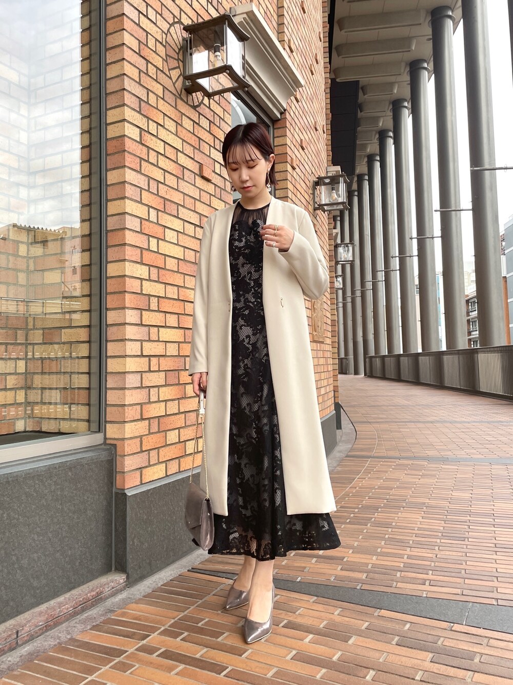 ブラック系のドレス、シルバー系のハンドバッグ、シルバー系のパンプスを着用したレディースの秋コーディネートの7枚目の写真