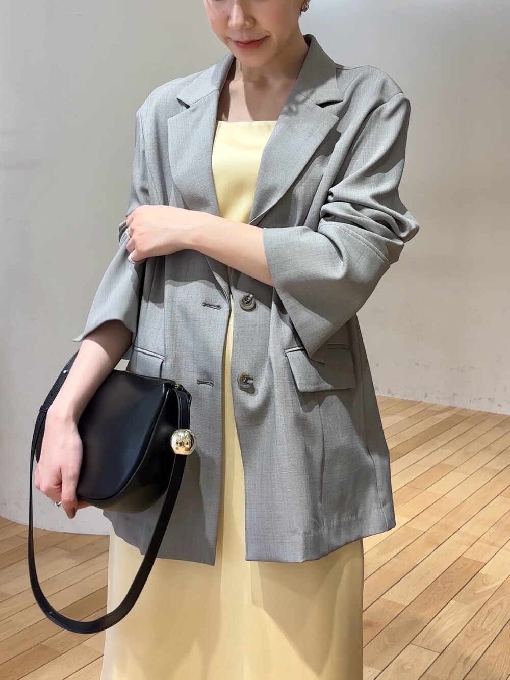 ホワイト系のワンピース、ホワイト系のテーラードジャケット、ブラック系のショルダーバッグを着用したレディースの春コーディネートの4枚目の写真