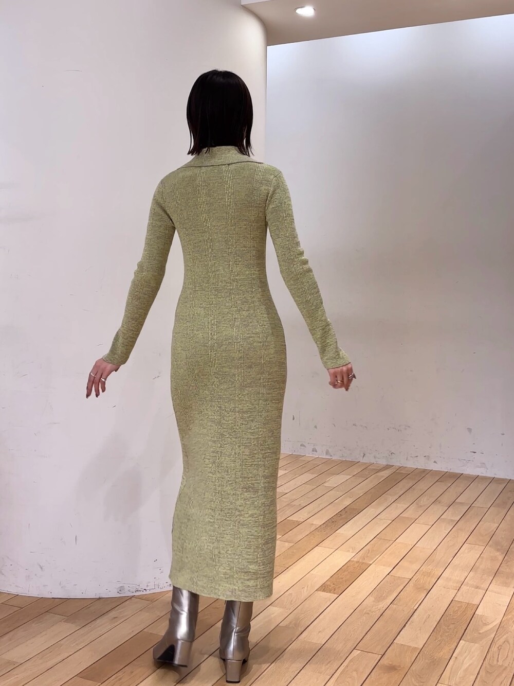 グリーン系のワンピース、シルバー系のブーツを着用したレディースの冬コーディネートの3枚目の写真