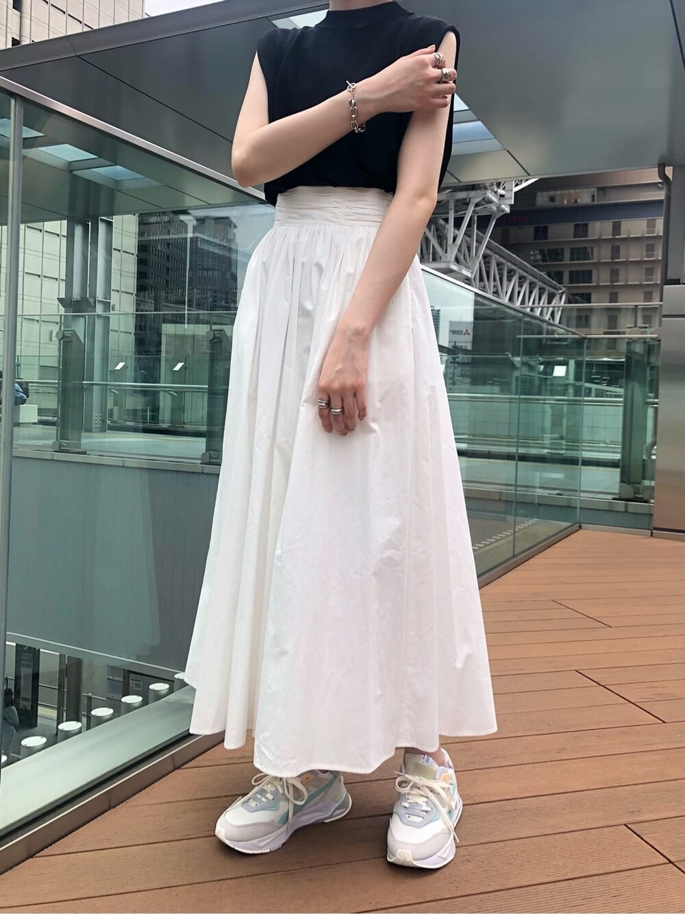 ブラック系のサンダル、ホワイト系のスカート、ブラック系のニット/セーターを着用したレディースの夏コーディネートの3枚目の写真