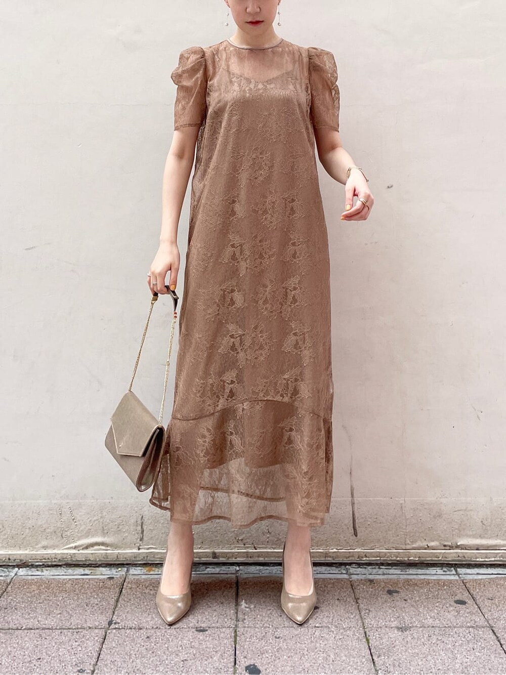 ゴールド系のパンプス、ゴールド系のクラッチバッグ、ベージュ系のドレスを着用したレディースの夏コーディネートの3枚目の写真