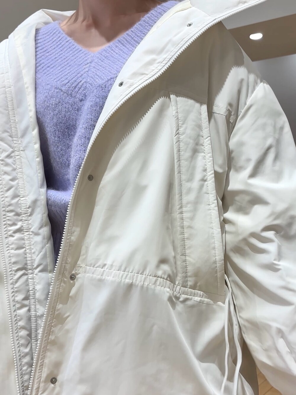 ブラック系のスカート、パープル系のニット/セーター、ホワイト系のダウンジャケット/コートを着用したレディースの冬コーディネートの6枚目の写真