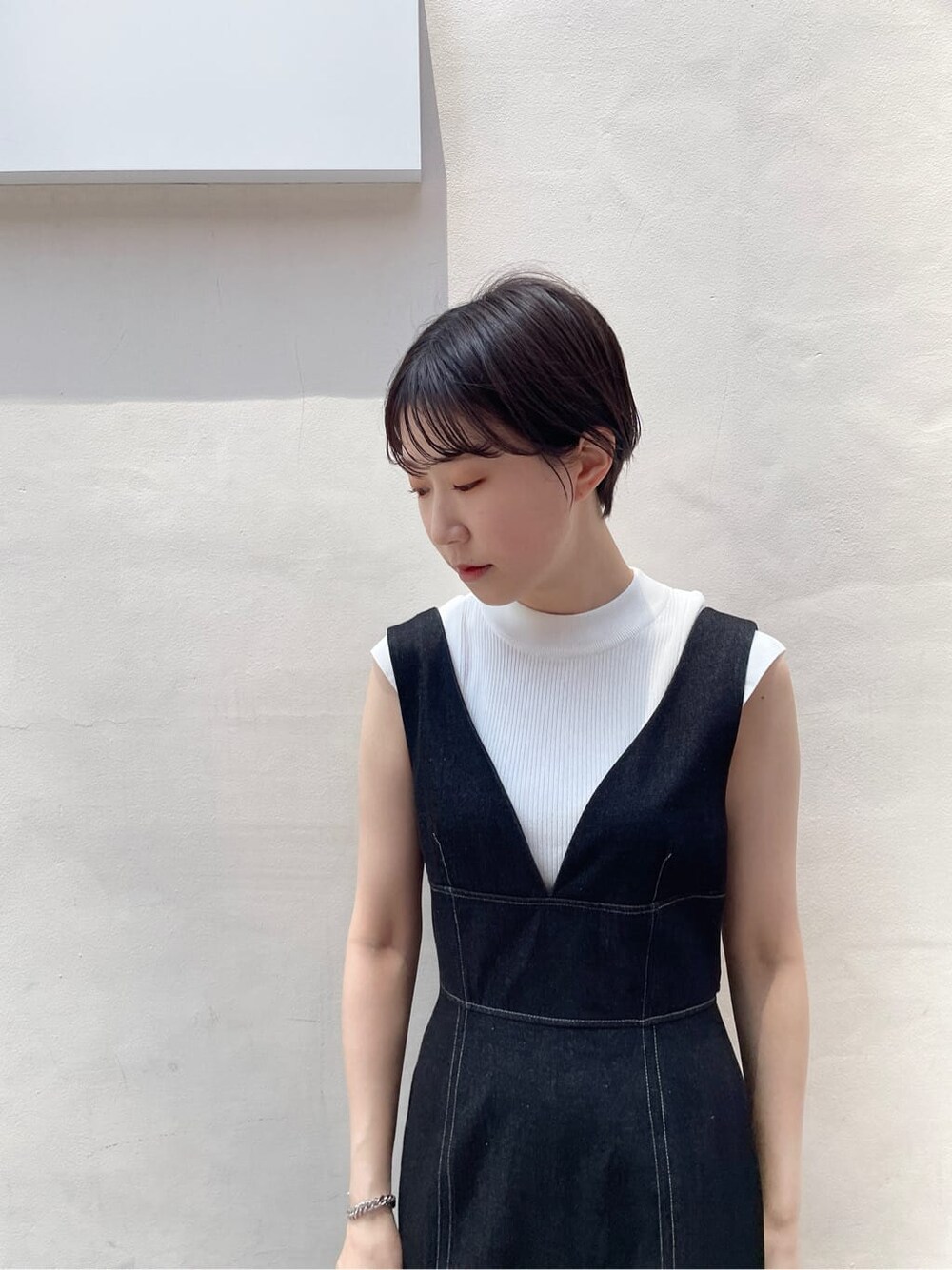 ベージュ系のサンダル、ブラック系のカーディガン/ボレロ、ブラック系のワンピースを着用したレディースの夏コーディネートの5枚目の写真