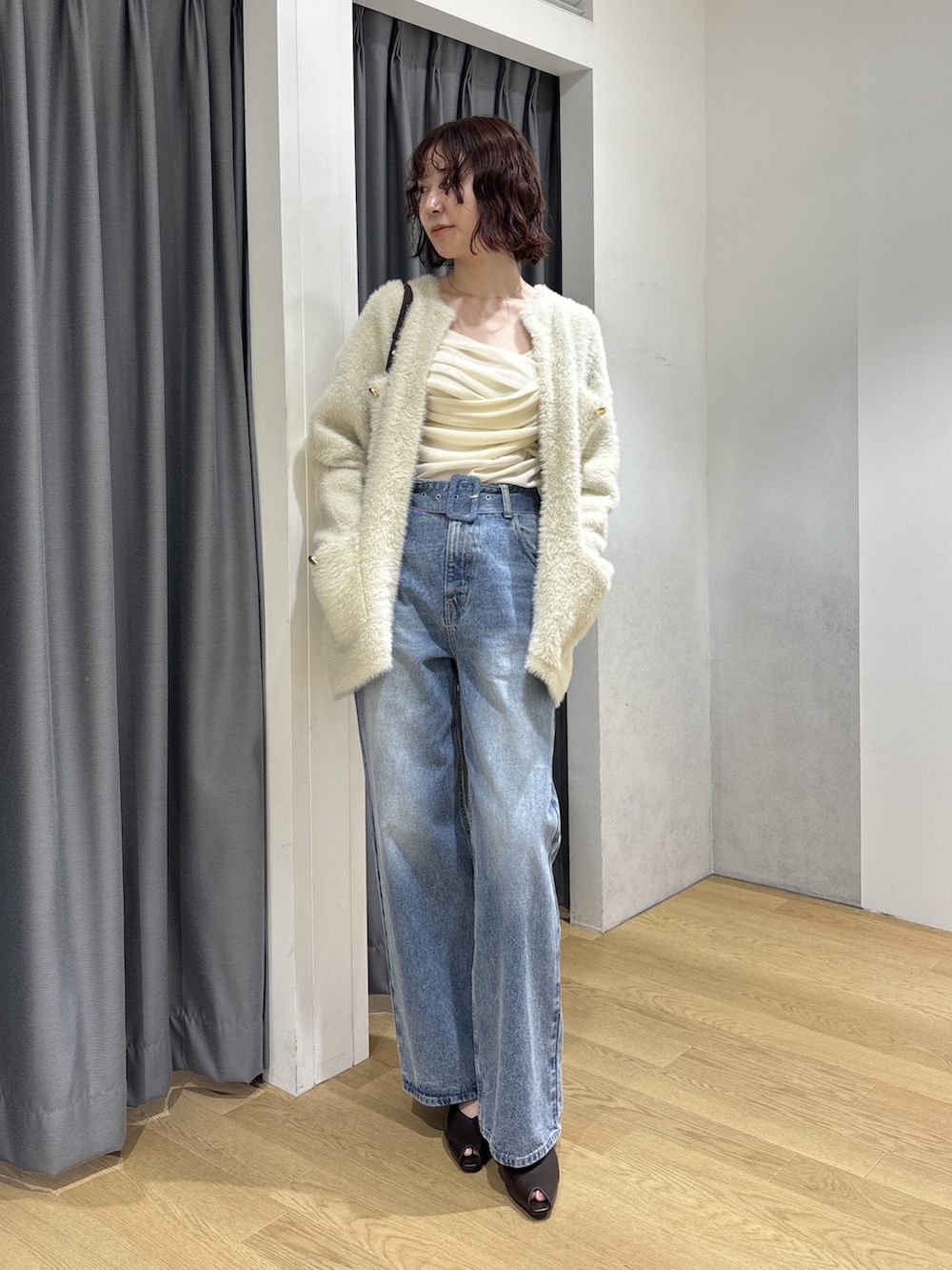 ホワイト系のカーディガン/ボレロ、ブラック系のハンドバッグ、ホワイト系のTシャツ/カットソーを着用したレディースの秋コーディネートの2枚目の写真