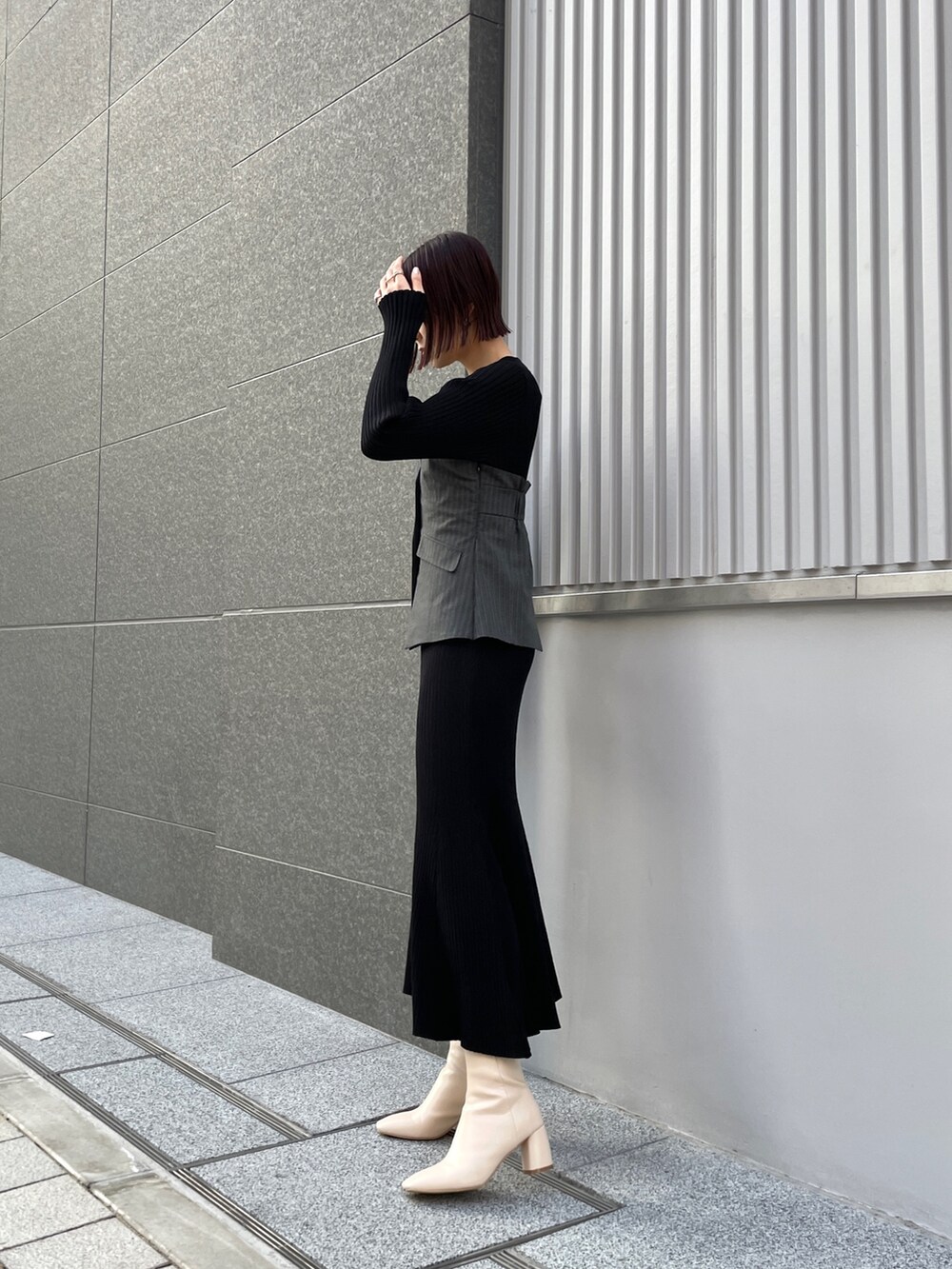 ホワイト系のブーツ、ブラック系のワンピース、ホワイト系のブルゾンを着用したレディースの冬コーディネートの3枚目の写真