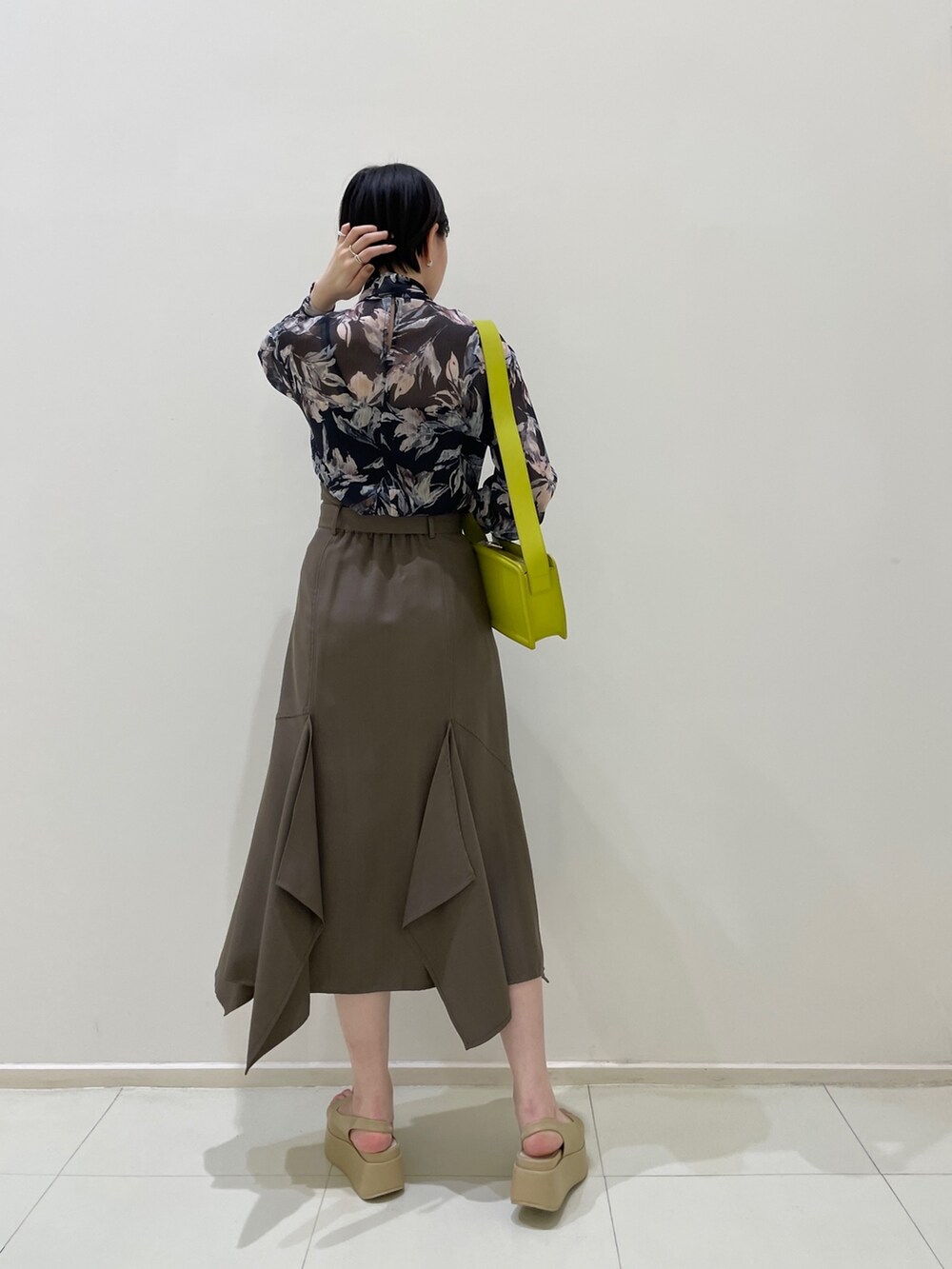 ブラウン系のスカート、ブルー系のシャツ/ブラウス、グリーン系のショルダーバッグを着用したレディースの春コーディネートの4枚目の写真