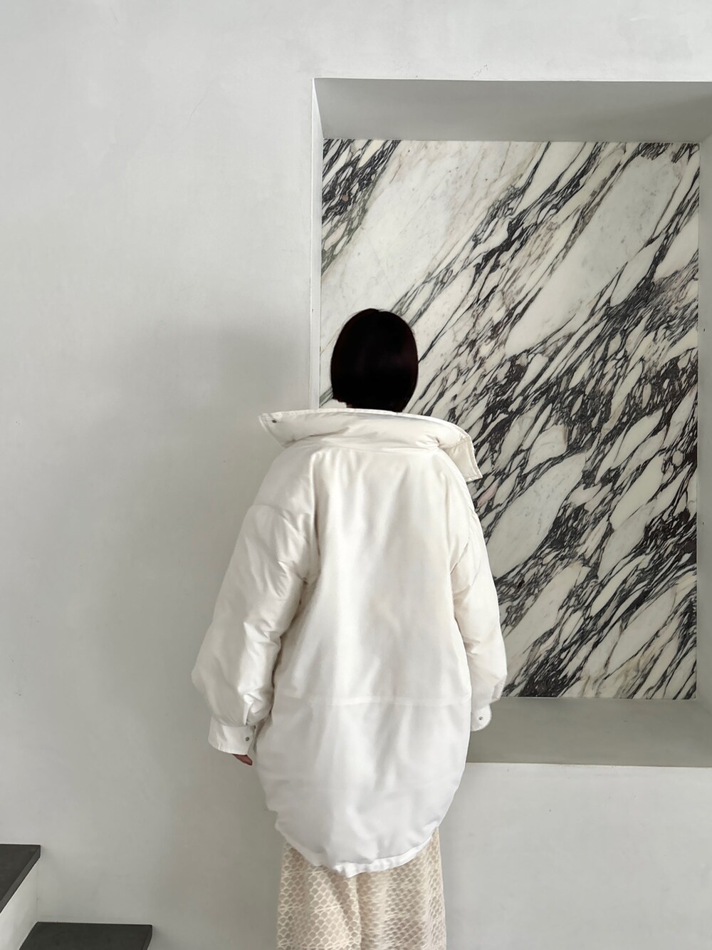 ホワイト系のワンピース、シルバー系のブーツ、ホワイト系のダウンジャケット/コートを着用したレディースの秋コーディネートの9枚目の写真