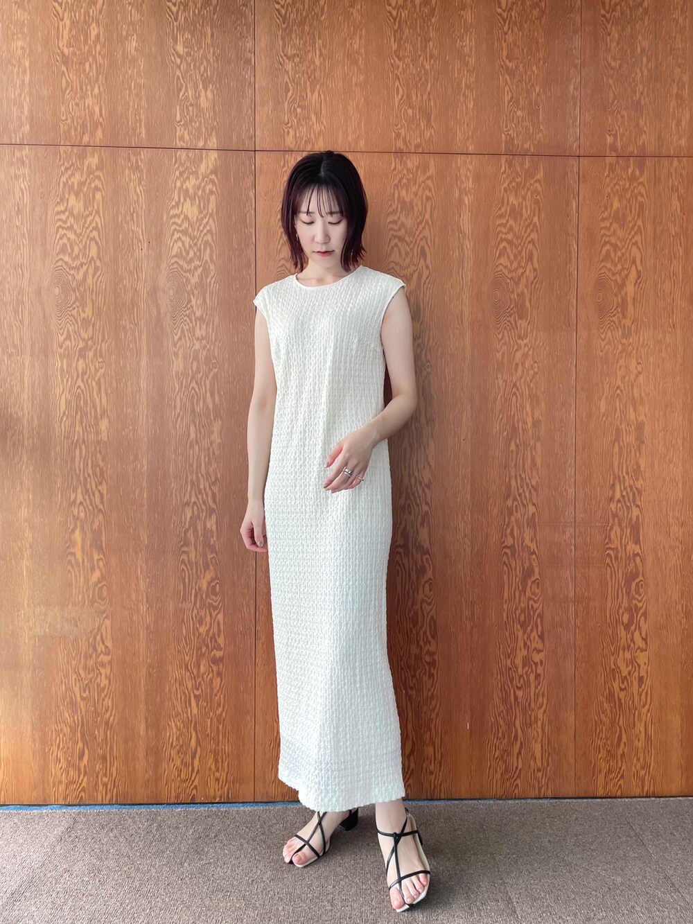 ブラック系のサンダル、ホワイト系のワンピースを着用したレディースの夏コーディネートの7枚目の写真