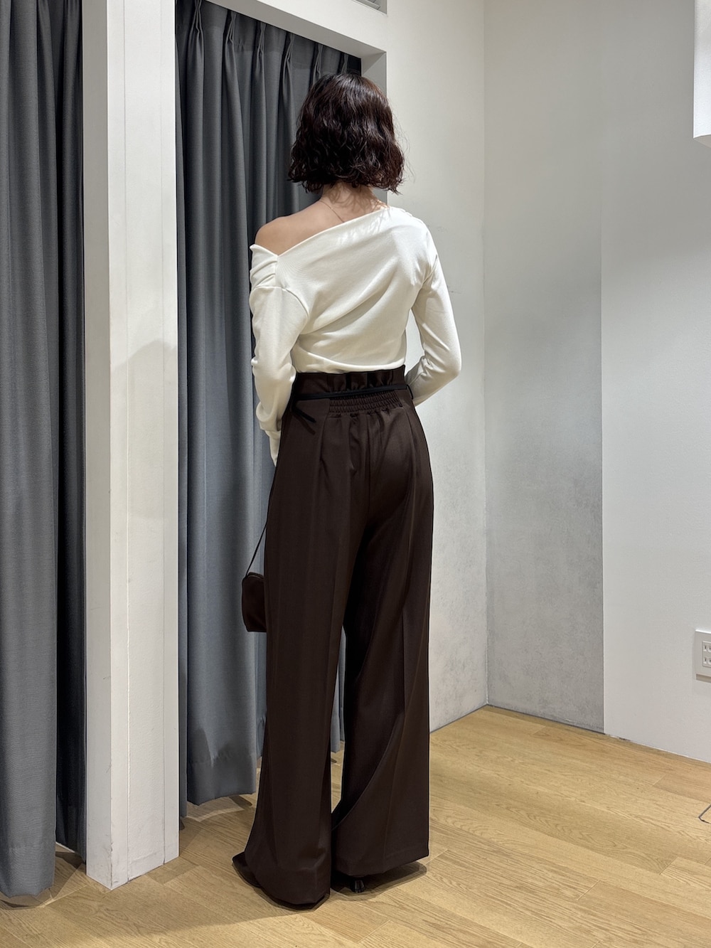 ブラウン系のその他パンツ、ホワイト系のニット/セーター、ブラウン系のハンドバッグを着用したレディースの秋コーディネートの3枚目の写真