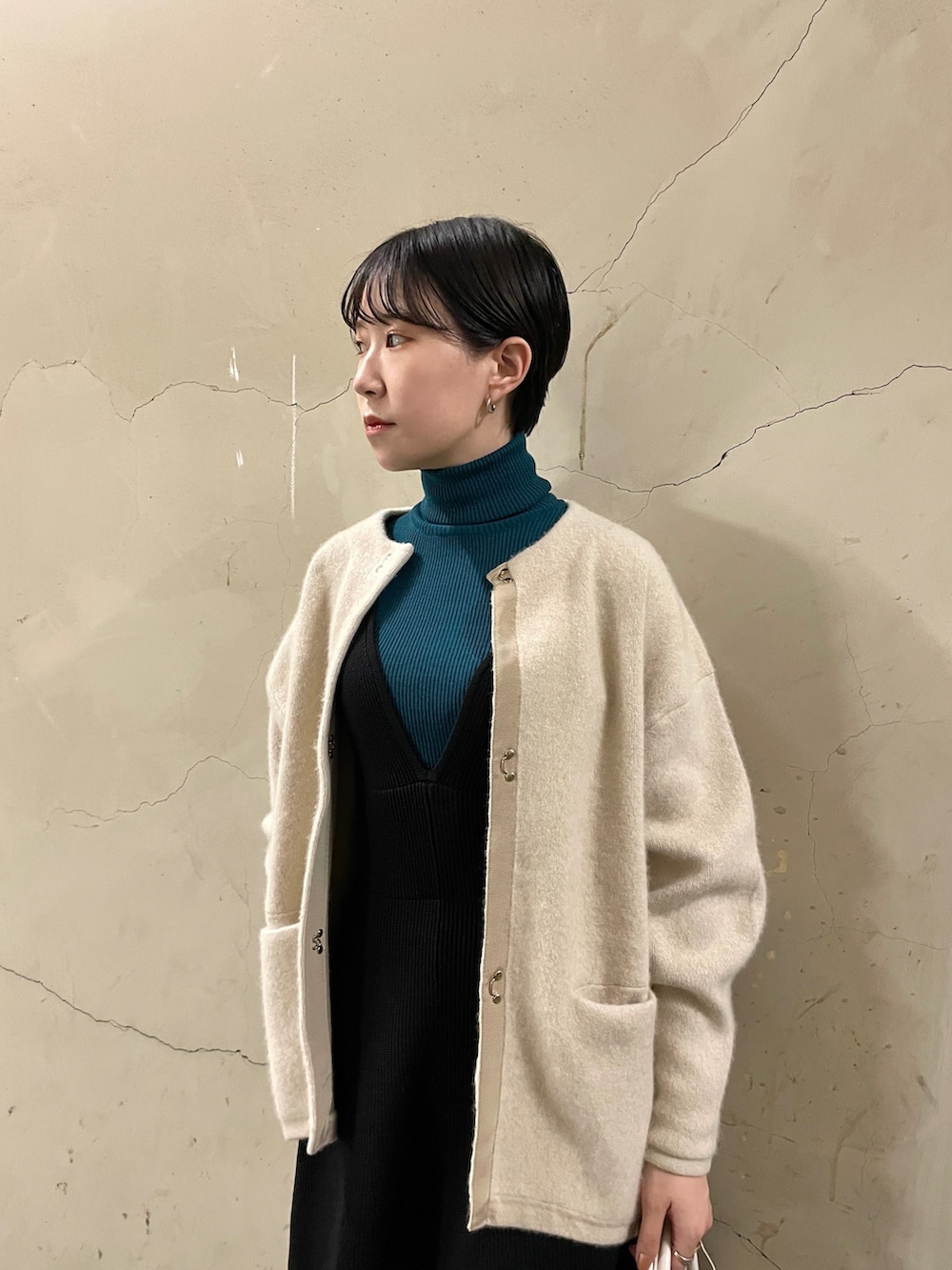 ブラック系のスカート、グリーン系のニット/セーター、ブラック系のブーツを着用したレディースの秋コーディネートの4枚目の写真