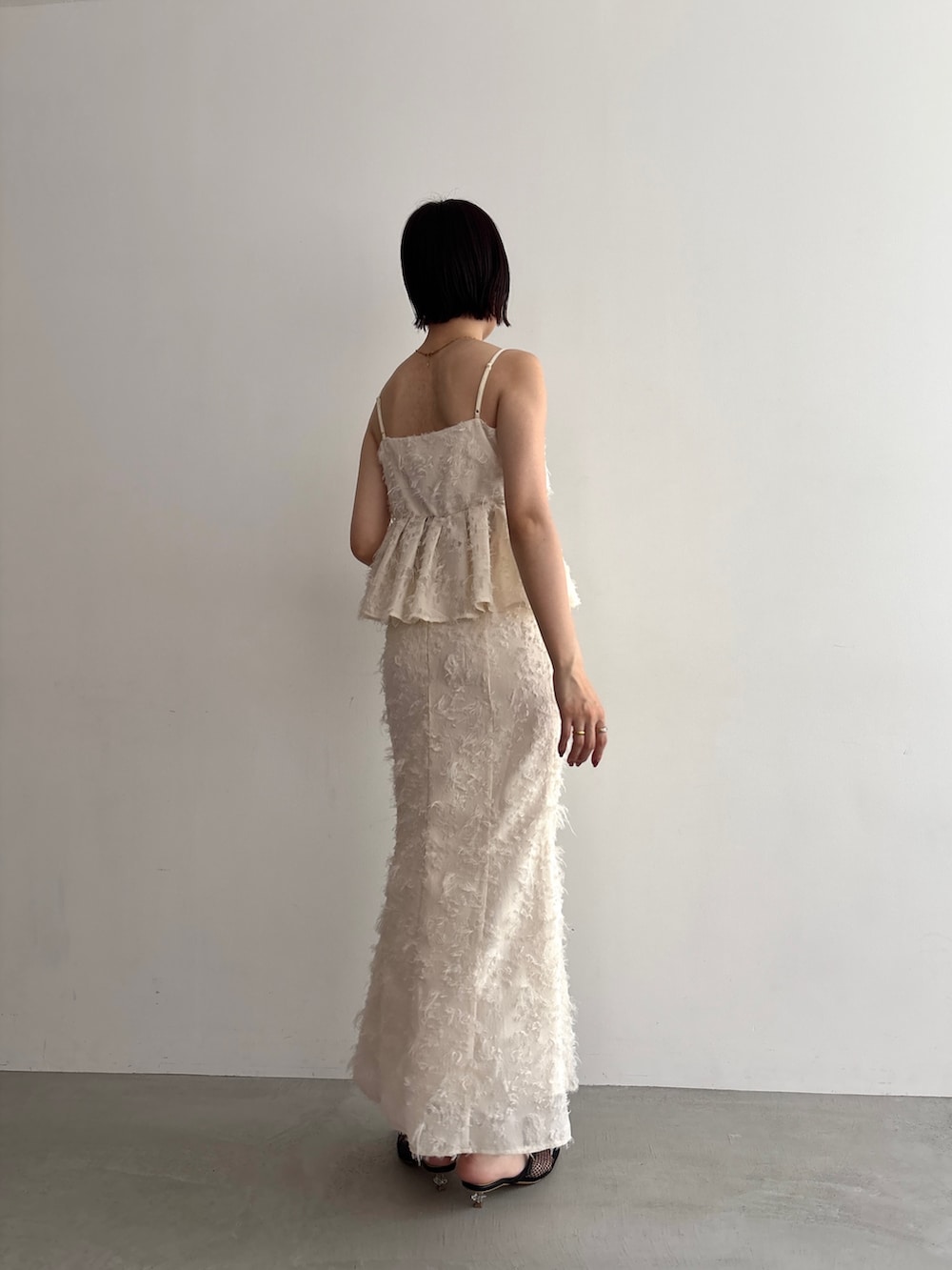 ホワイト系のキャミソール、ホワイト系のスカートを着用したレディースの夏コーディネートの4枚目の写真