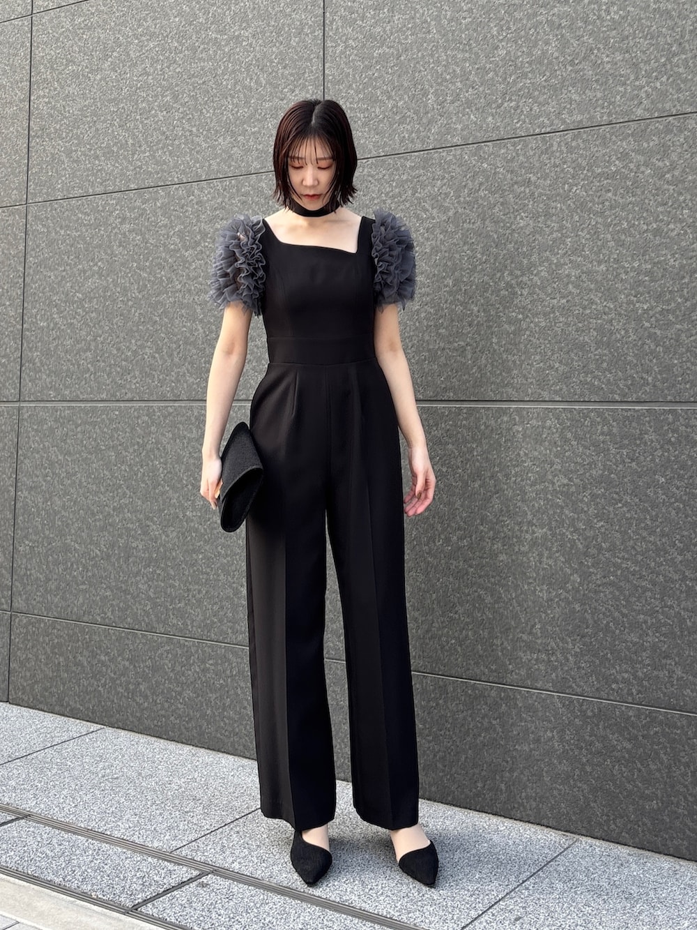 ブラック系のドレス、ブラック系のパンプス、ブラック系のハンドバッグを着用したレディースの冬コーディネートの2枚目の写真