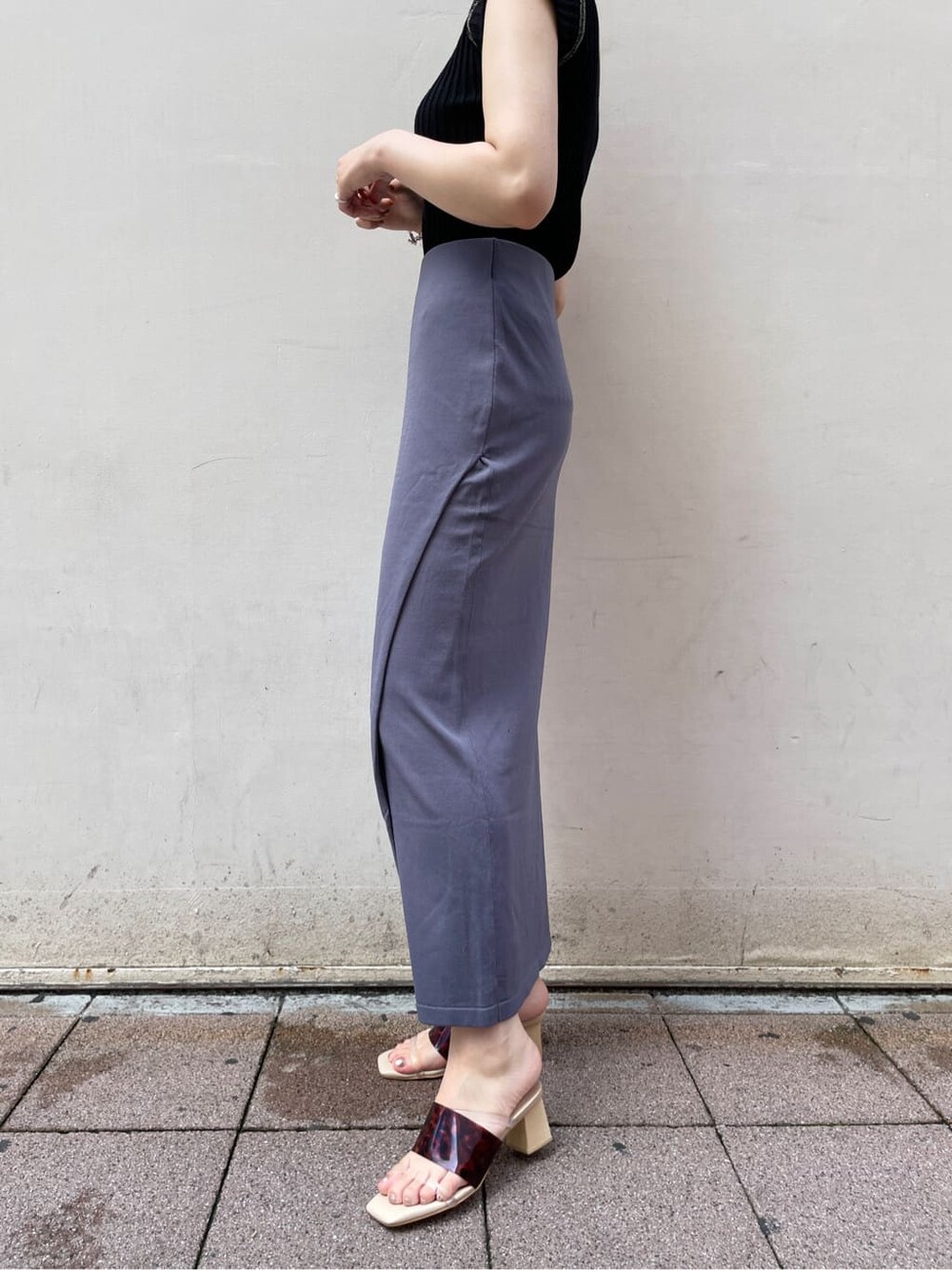 ホワイト系のサンダル、ブルー系のスカート、ブラック系のニット/セーターを着用したレディースの夏コーディネートの5枚目の写真