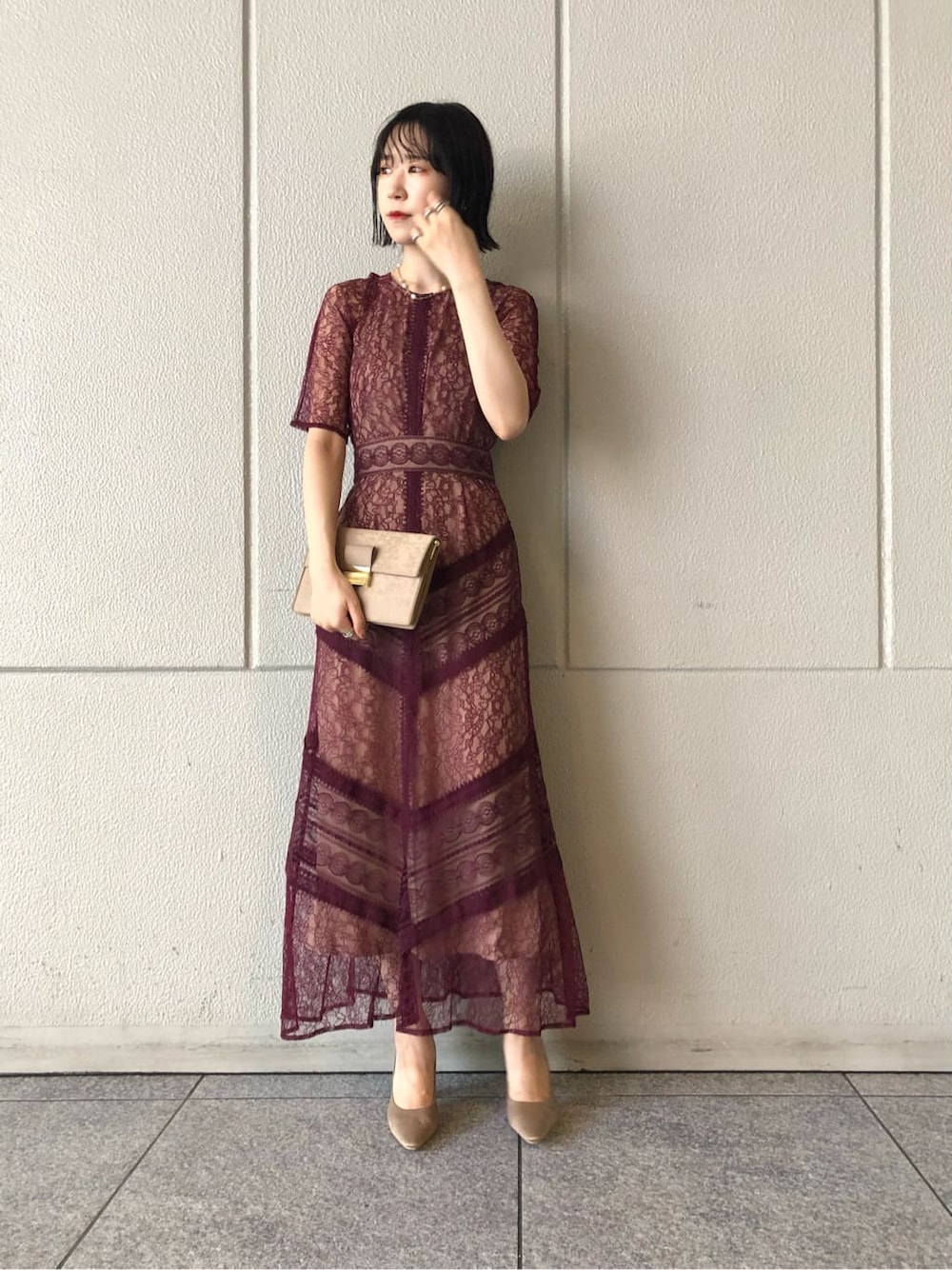 レッド系のドレス、ベージュ系のパンプス、ベージュ系のクラッチバッグを着用したレディースの秋コーディネートの3枚目の写真