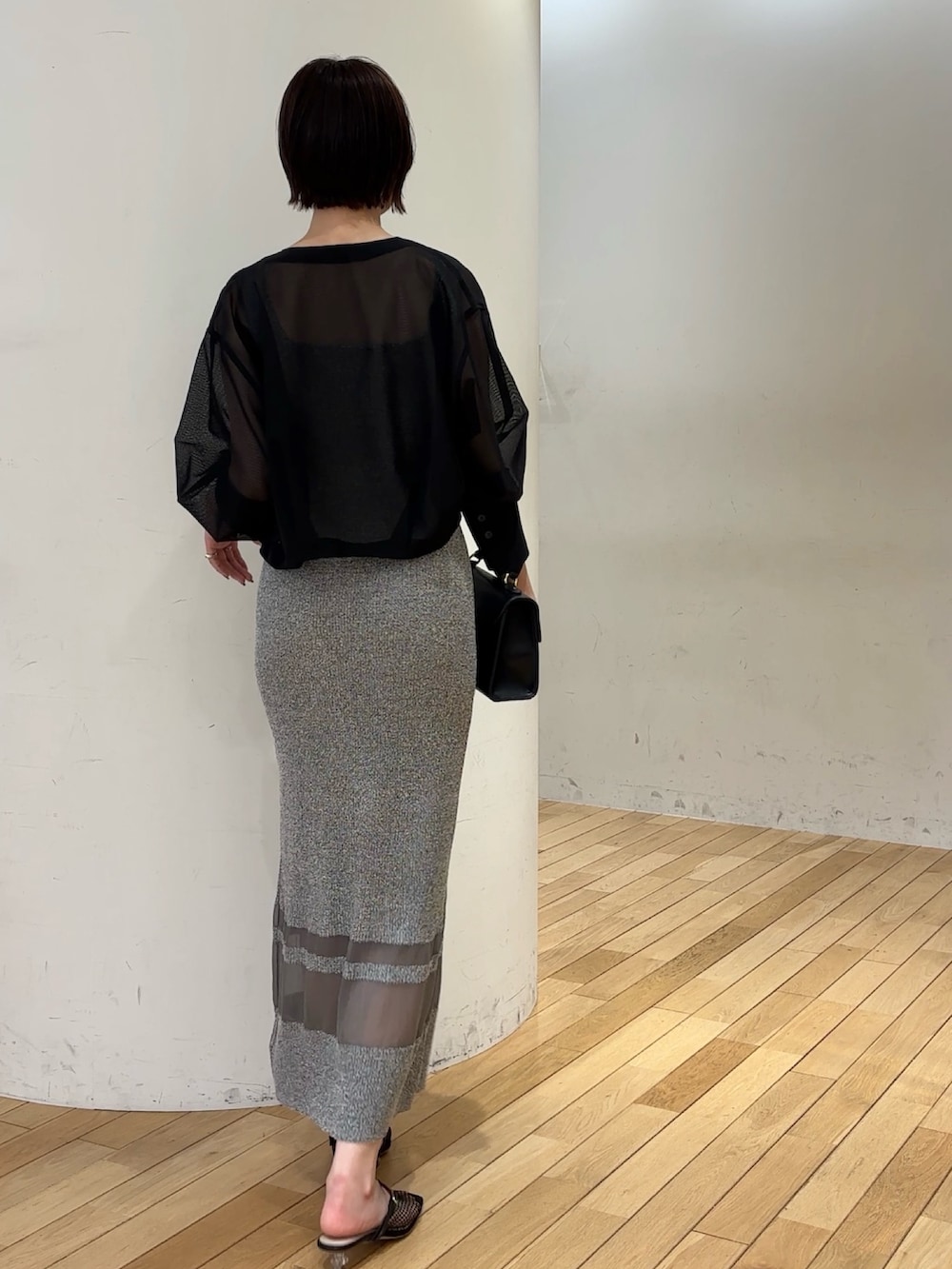 グレー系のワンピース、ブラック系のブルゾン、ブラック系のハンドバッグを着用したレディースの春コーディネートの3枚目の写真