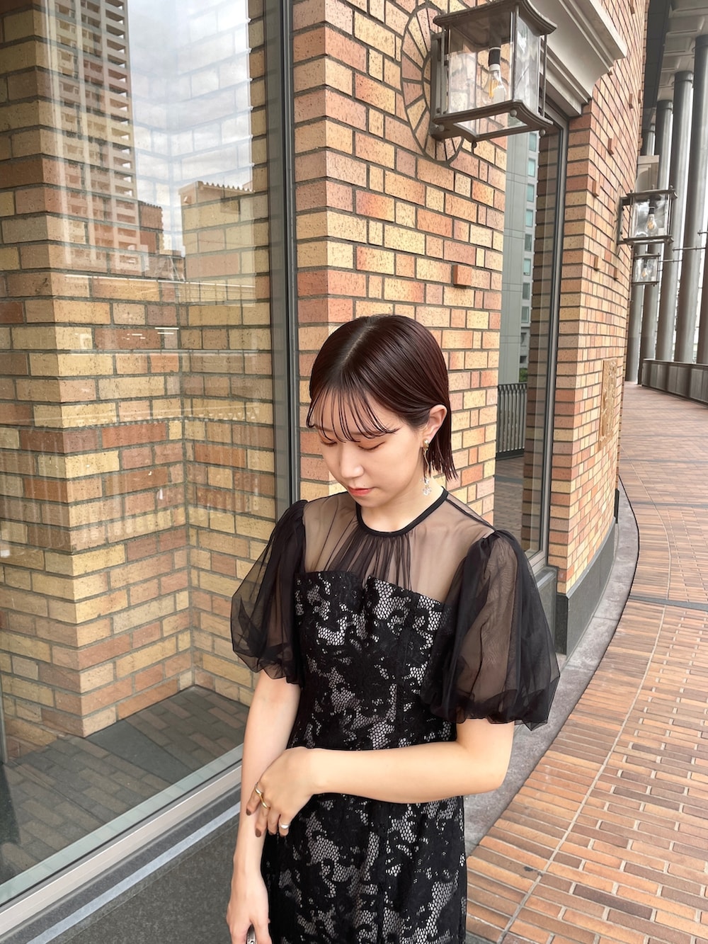 ブラック系のドレス、シルバー系のハンドバッグ、シルバー系のパンプスを着用したレディースの秋コーディネートの5枚目の写真