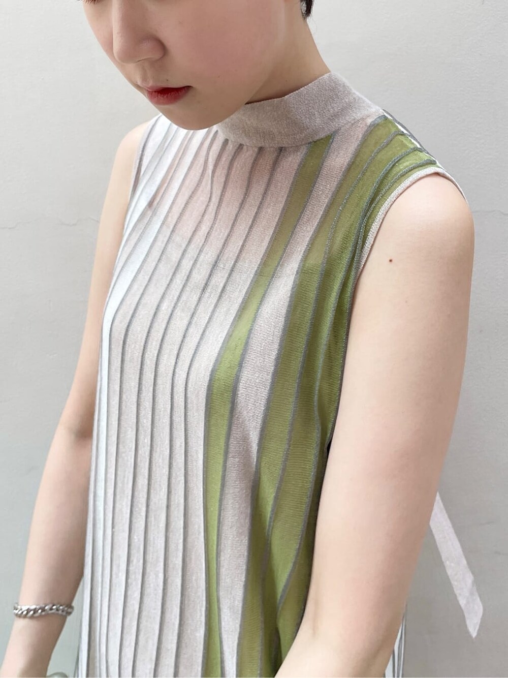 グリーン系のワンピース、グリーン系のカーディガン/ボレロ、ベージュ系のサンダルを着用したレディースの夏コーディネートの5枚目の写真