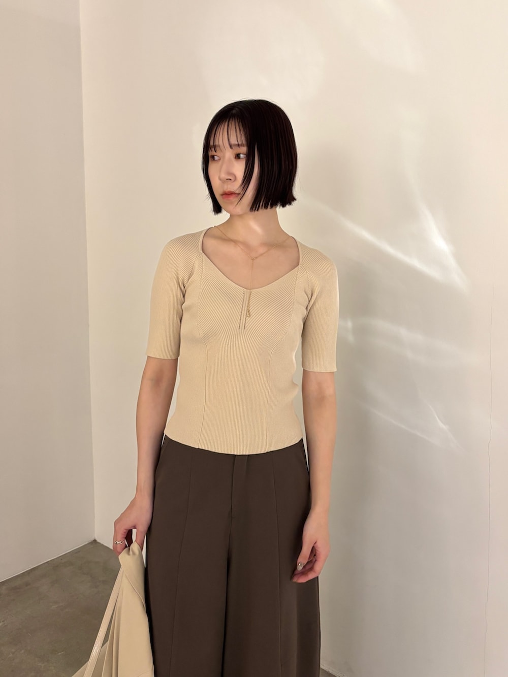 シルバー系のパンプス、ブラウン系のその他パンツ、ベージュ系のテーラードジャケットを着用したレディースの春コーディネートの5枚目の写真