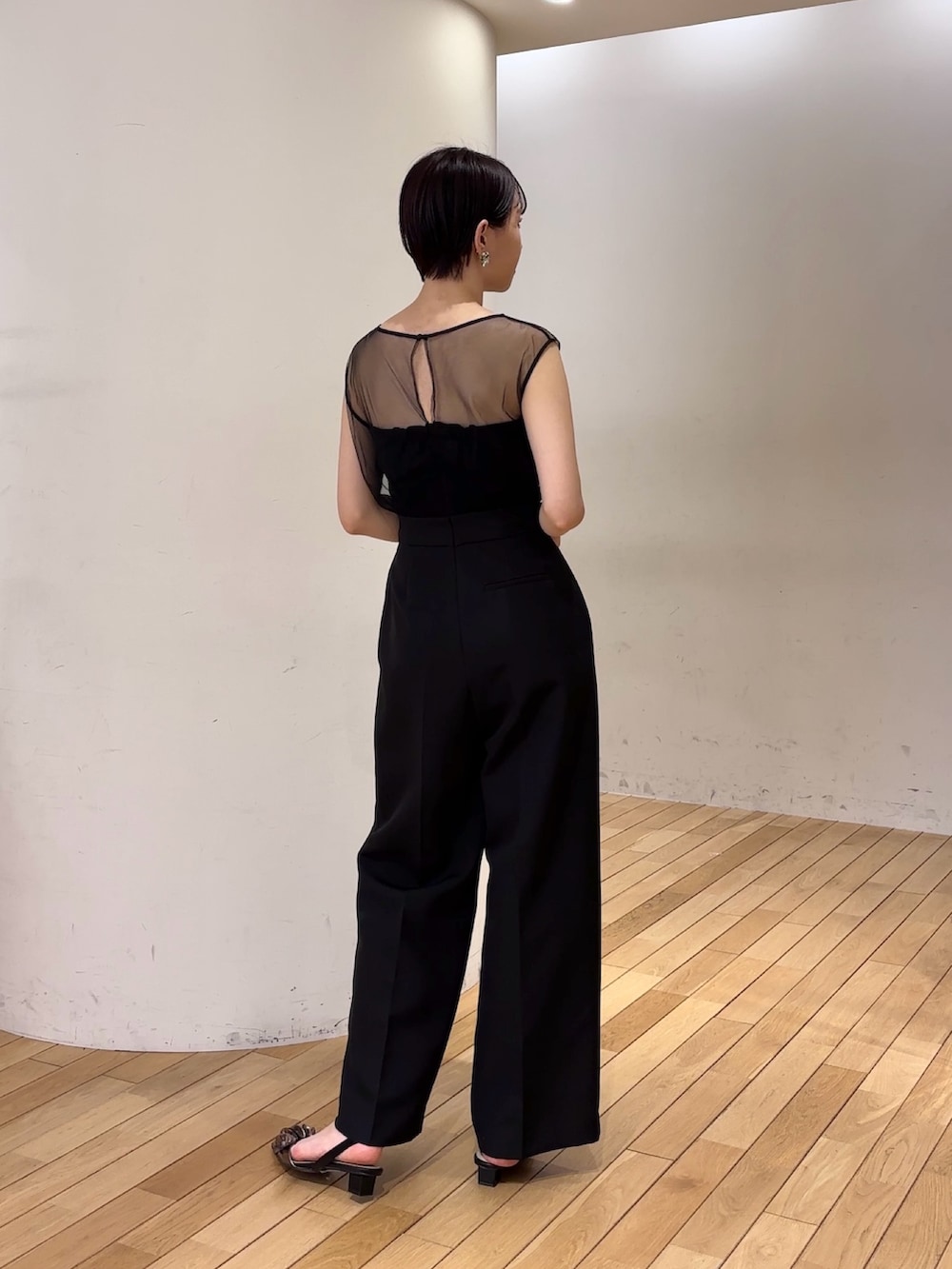 ブラック系のパンツドレス、ブラック系のショルダーバッグ、その他のパンプスを着用したレディースの春コーディネートの4枚目の写真