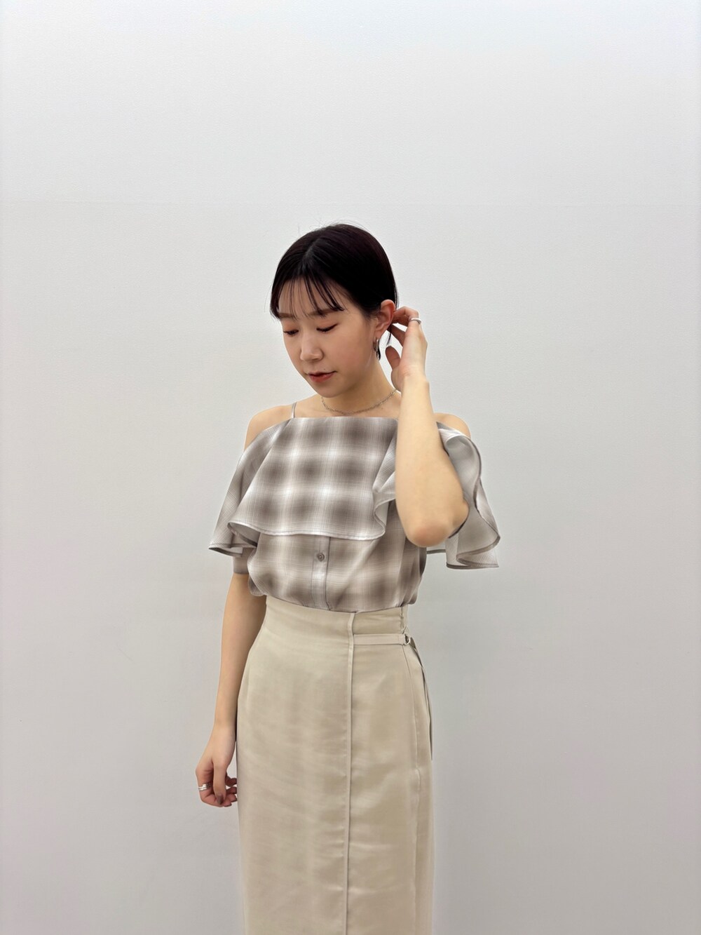 ベージュ系のシャツ/ブラウス、ホワイト系のスカート、ホワイト系のサンダルを着用したレディースの春コーディネートの5枚目の写真