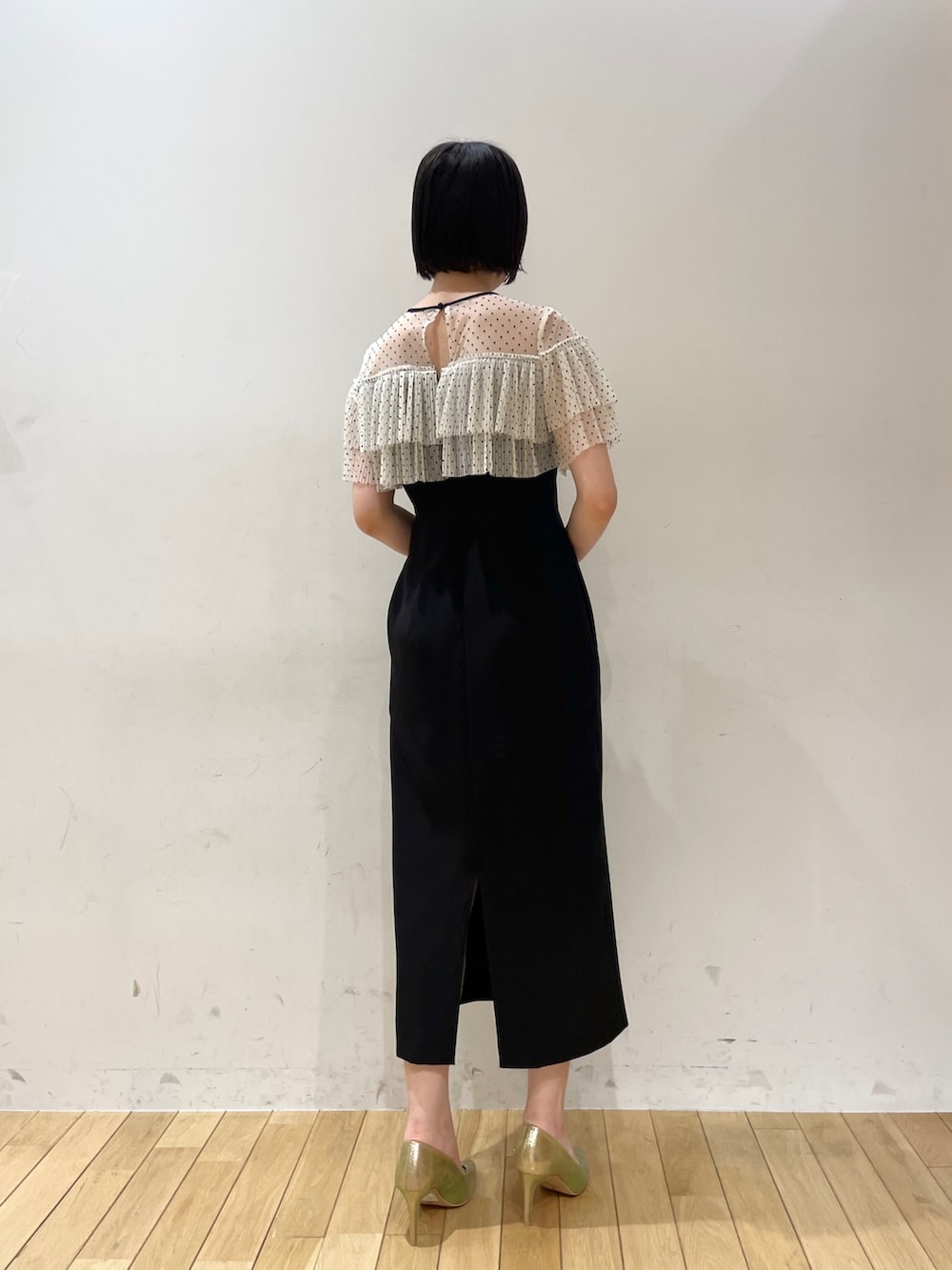 ゴールド系のハンドバッグ、ブラック系のドレス、ゴールド系のパンプスを着用したレディースの夏コーディネートの4枚目の写真
