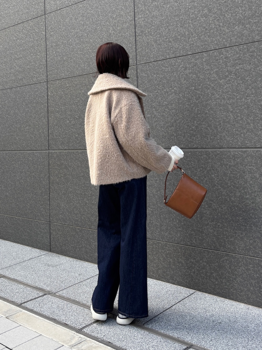 ブルー系のデニムパンツ、ベージュ系のその他アウター、ホワイト系のニット/セーターを着用したレディースの冬コーディネートの4枚目の写真