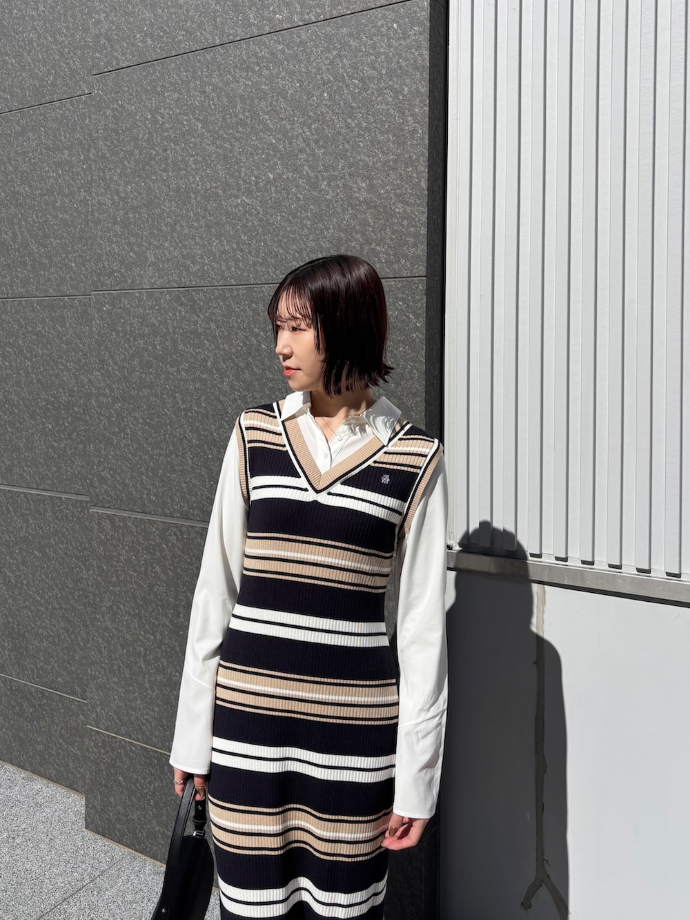 ベージュ系のワンピース、ブラック系のハンドバッグを着用したレディースの春コーディネートの5枚目の写真