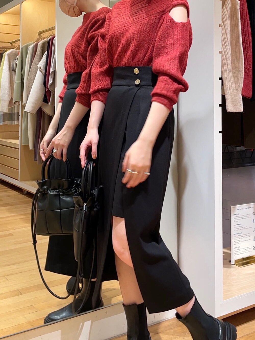 ブラック系のスカート、ブラック系のニット/セーター、ブラック系のハンドバッグを着用したレディースの冬コーディネートの3枚目の写真